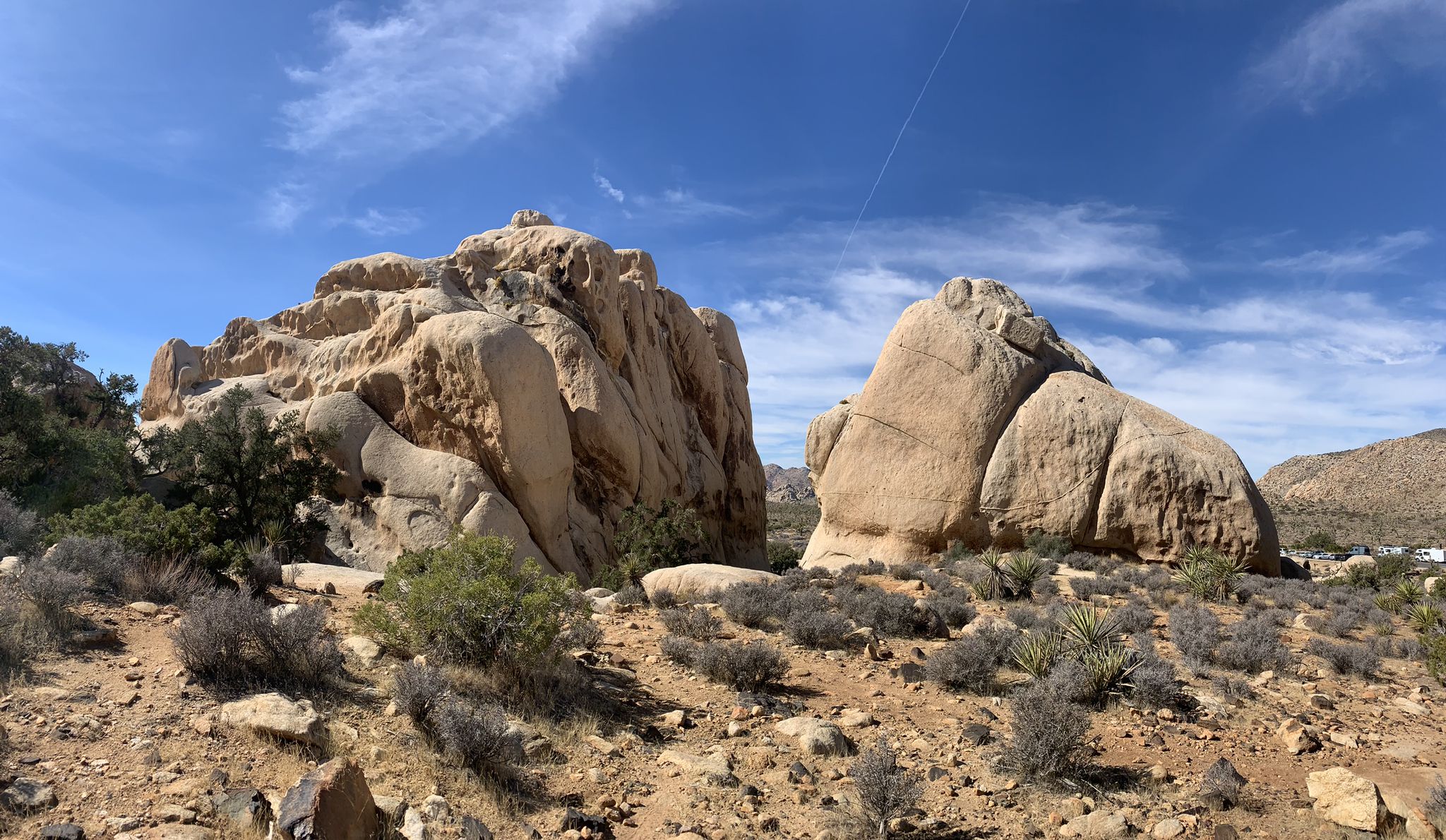 Two massive rock formations dominate a desert landscape under a bright blue sky. - Ryan Mountain Trail