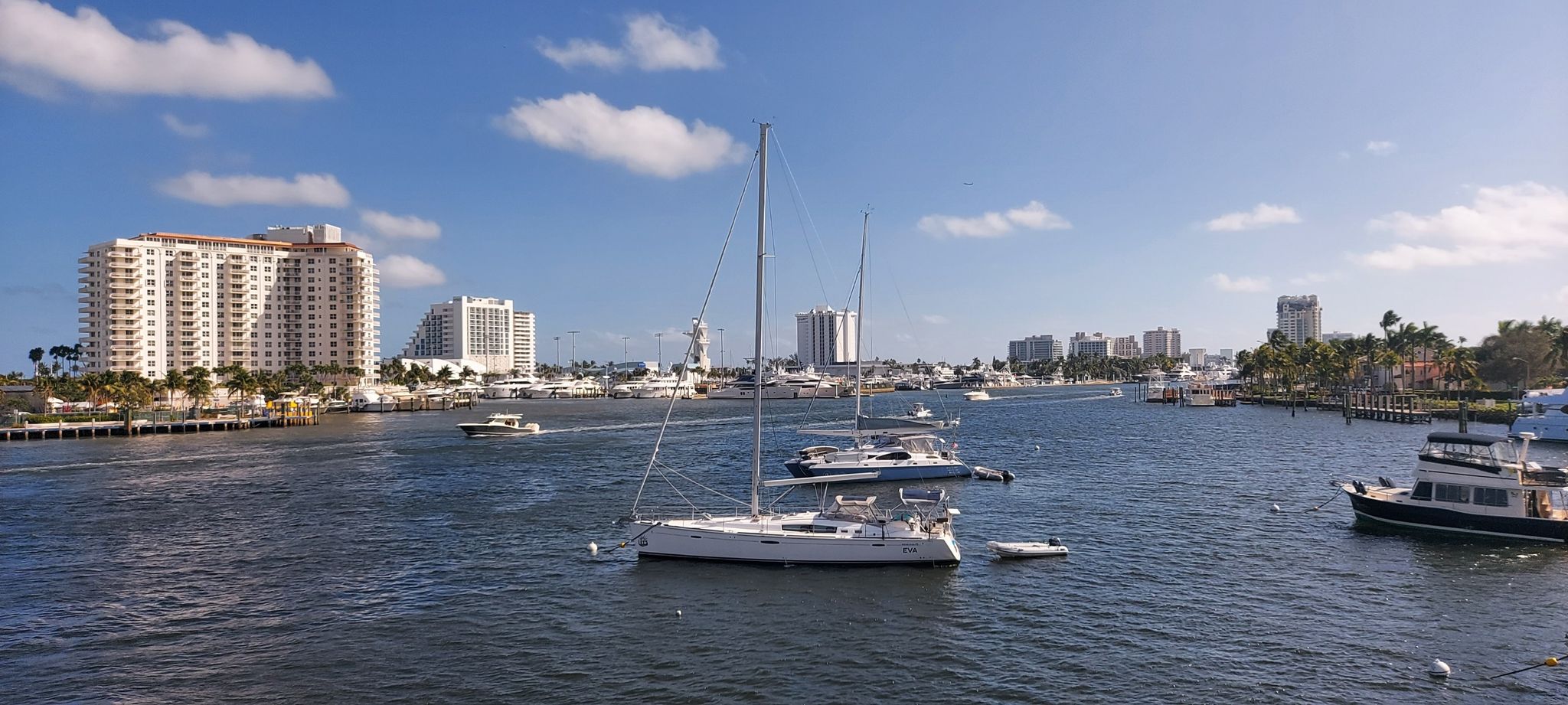 Boats on a wide river with city buildings and a bright blue sky. - East Coast Greenway: Fort Lauderdale Loop
