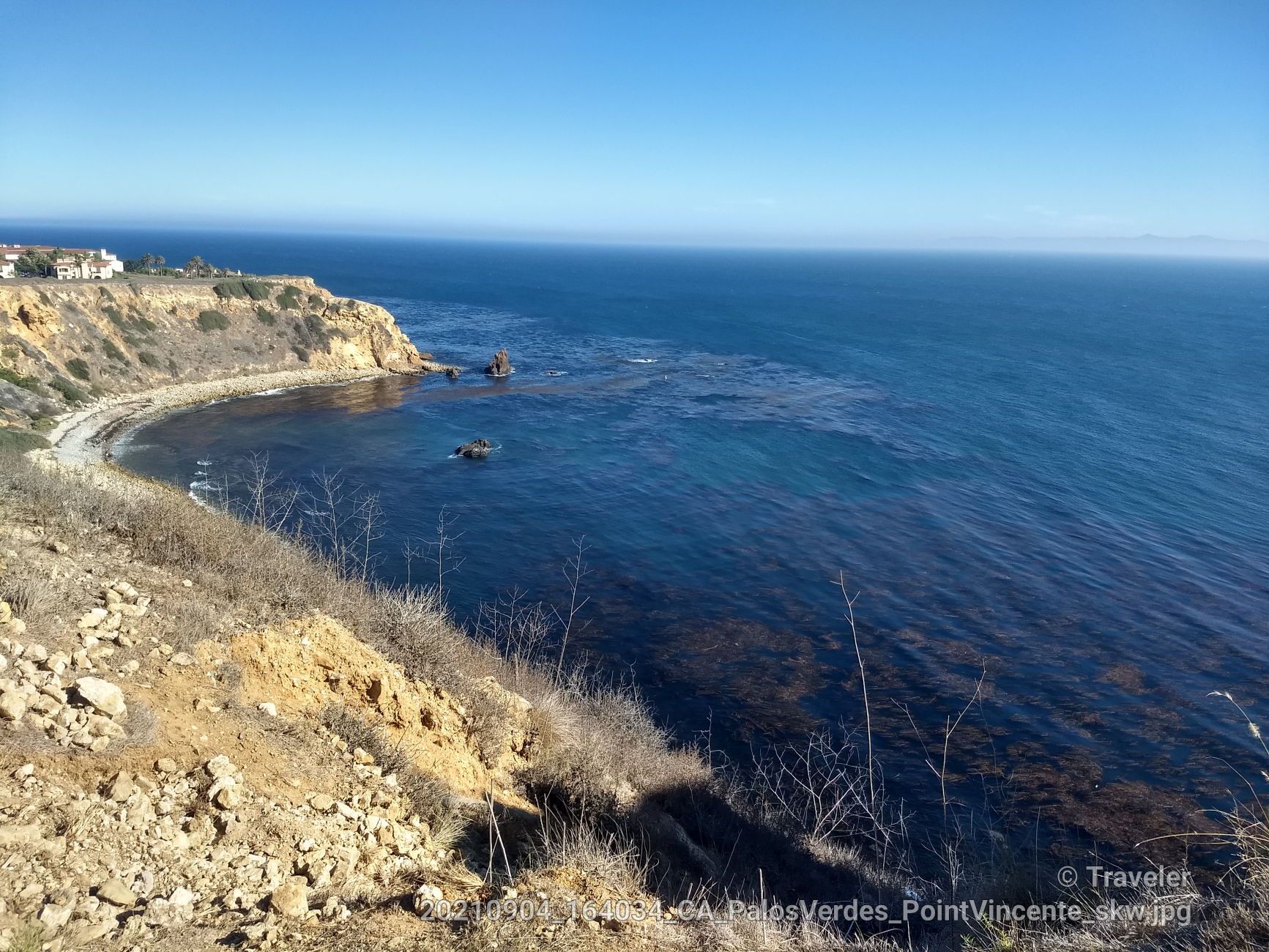 Rugged cliff overlooking a deep blue ocean with small coves and rocks. - Palos Verdes coastal loop from Entradero
