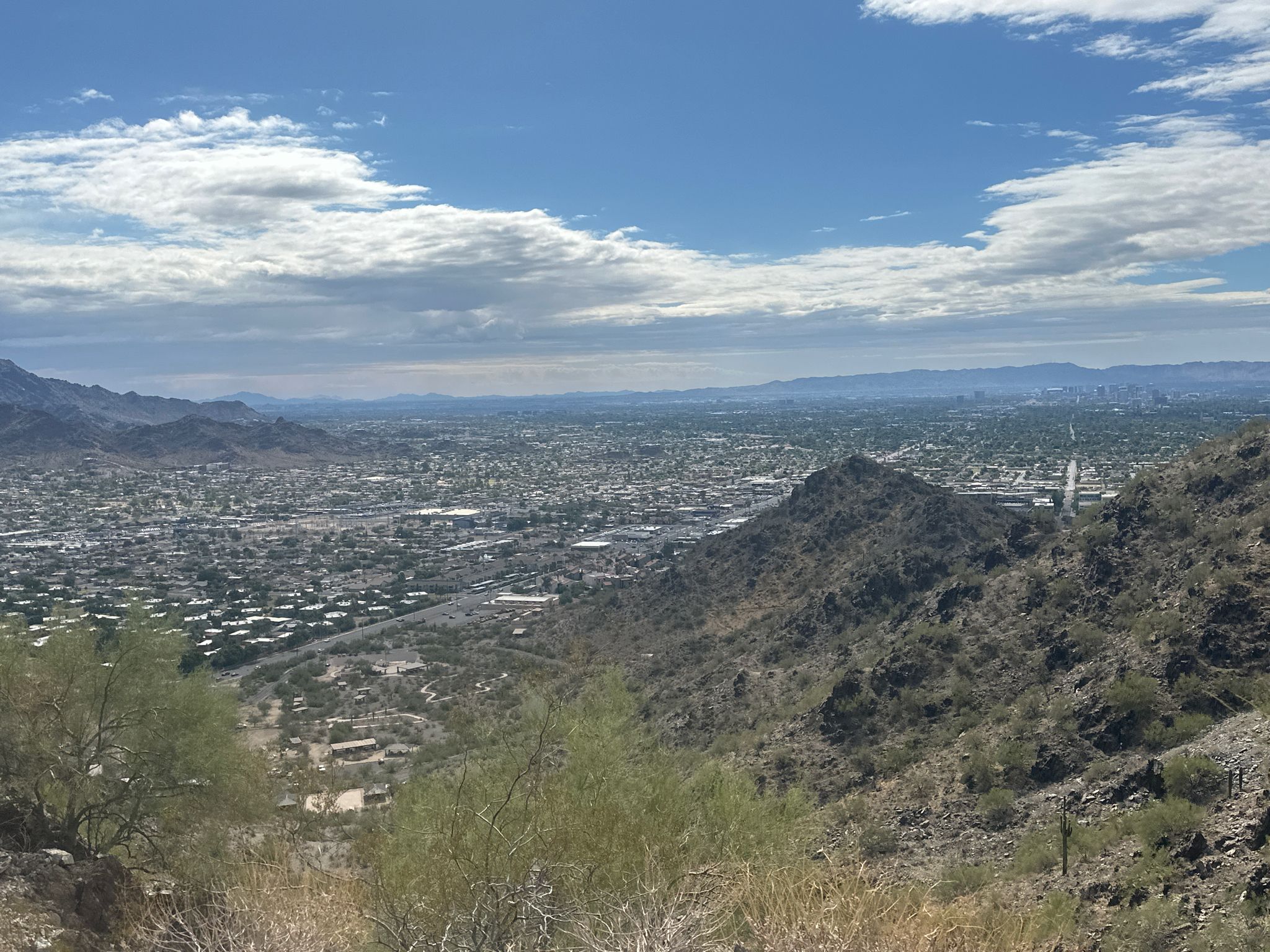 Panoramic view of a city in a desert valley, surrounded by rocky mountains. - North Mountain loop from Sunnyslope Mountain