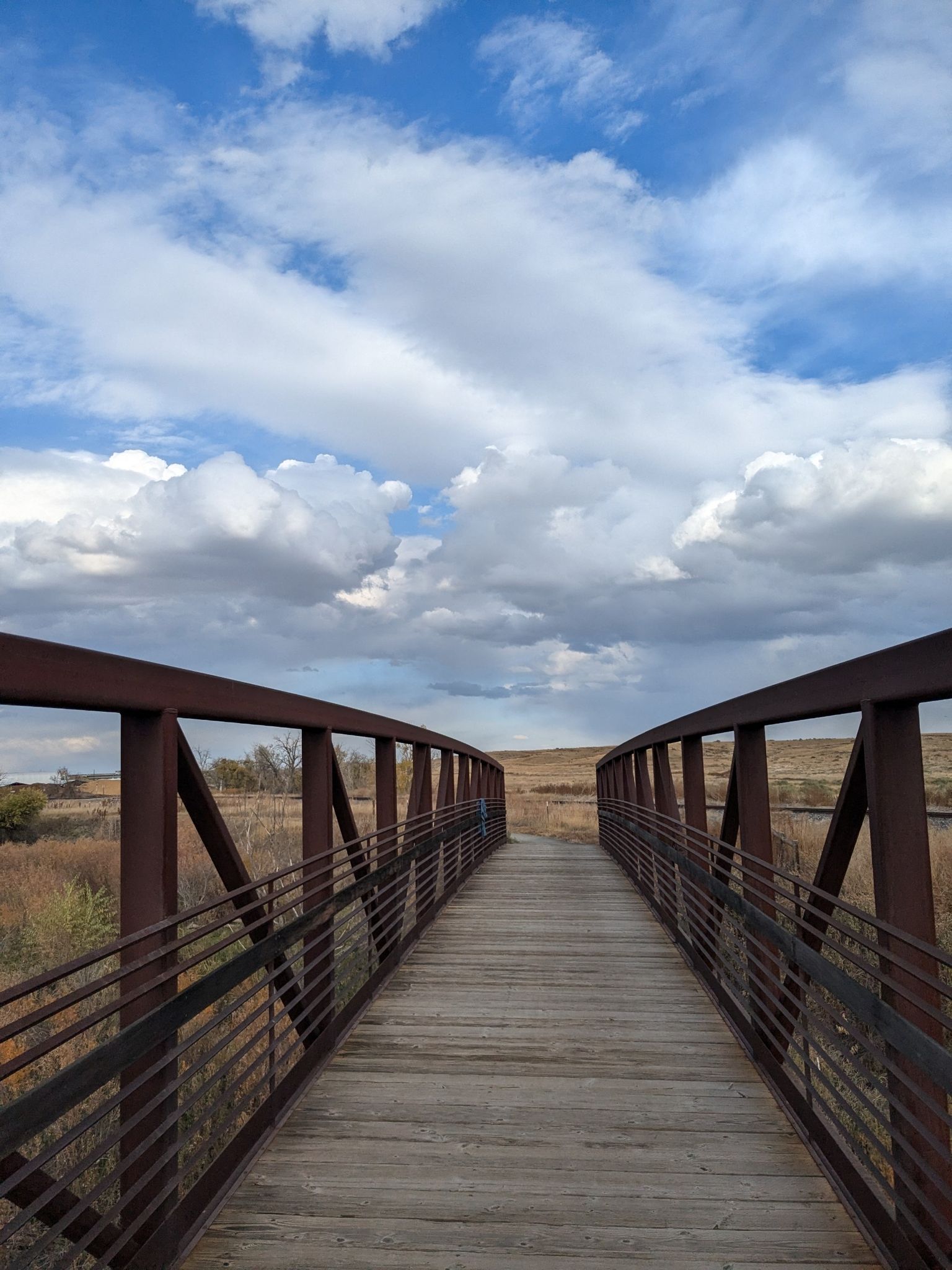 A metal and wood bridge extending over a dry landscape under a cloudy sky. - Cradleboard Trail – Sterns Lake loop from Admor Open Space