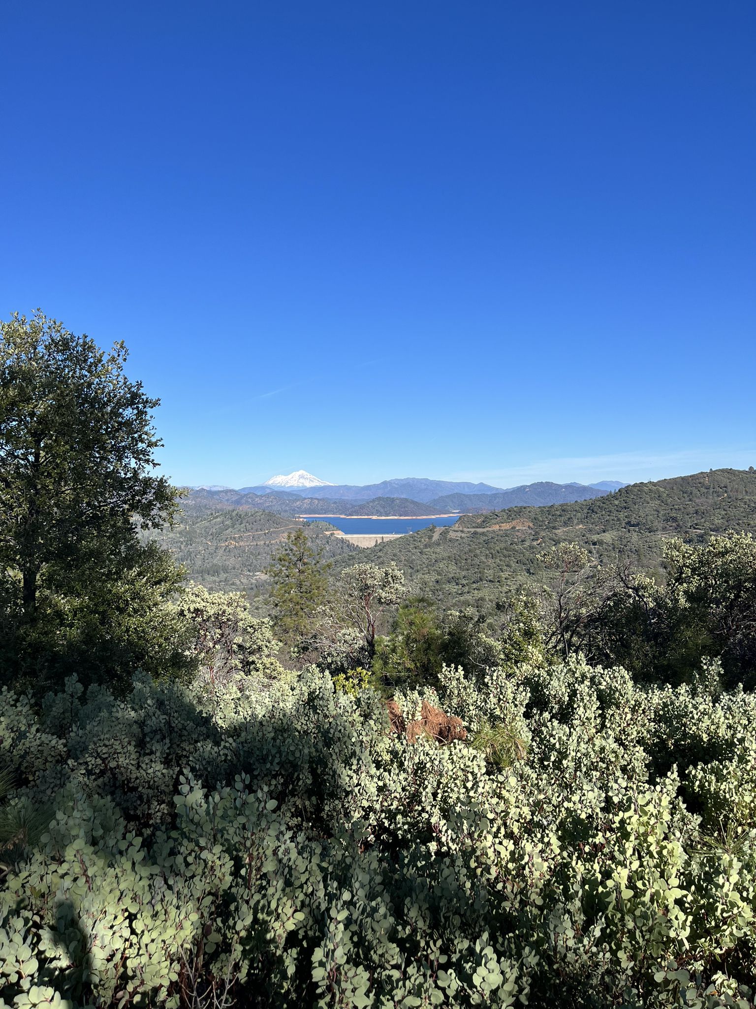 Vast mountainous landscape with a lake, distant snow-capped peak under clear blue sky. - Chamise Peak loop from chamise Peak