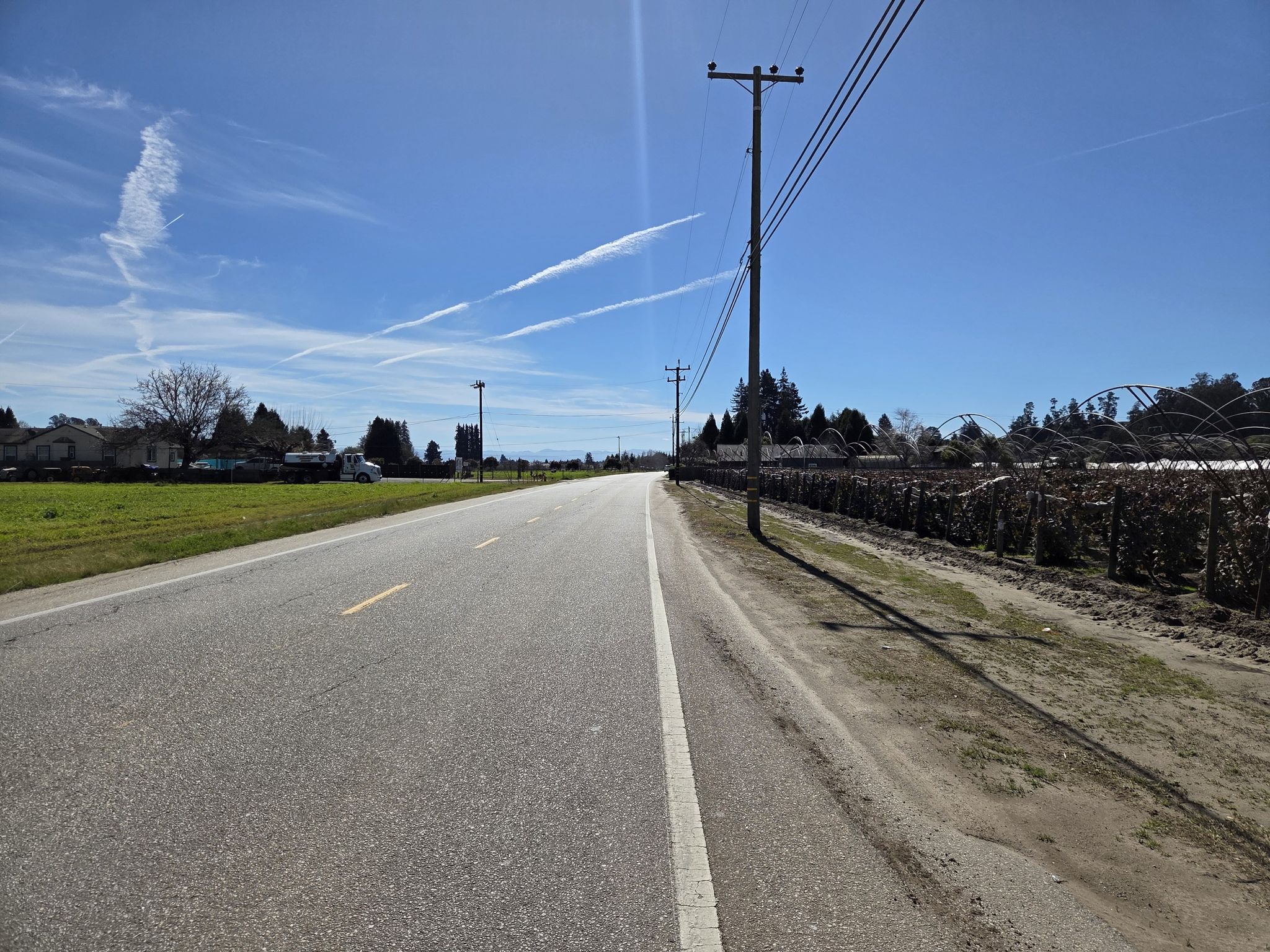 Long paved road with power lines and fields under a bright, sunny sky. - Seacliff State Beach – Aptos Village loop from Seacliff State Beach