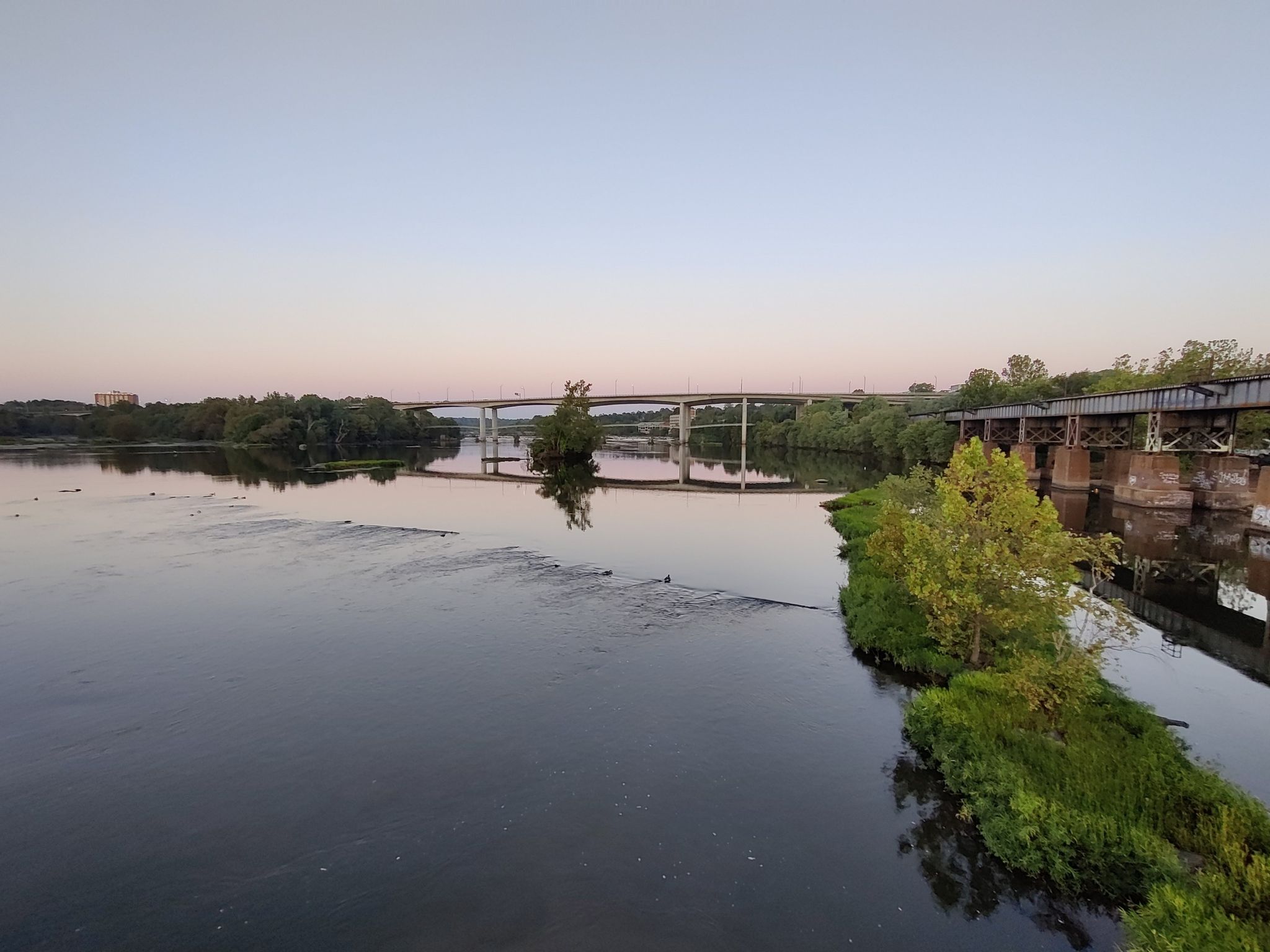 Wide river with distant bridges under a soft, clear sky at dusk. - Pedestrian bridge – LOVE Sign on Brown's Island loop from Manchester