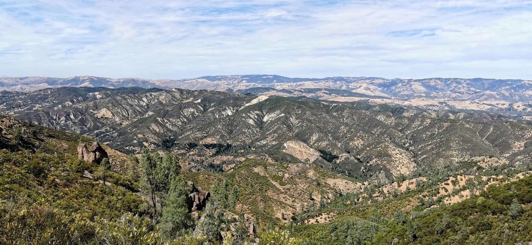 Panoramic view of rugged, rolling hills covered in green and brown vegetation. - Bear Gulch Trail