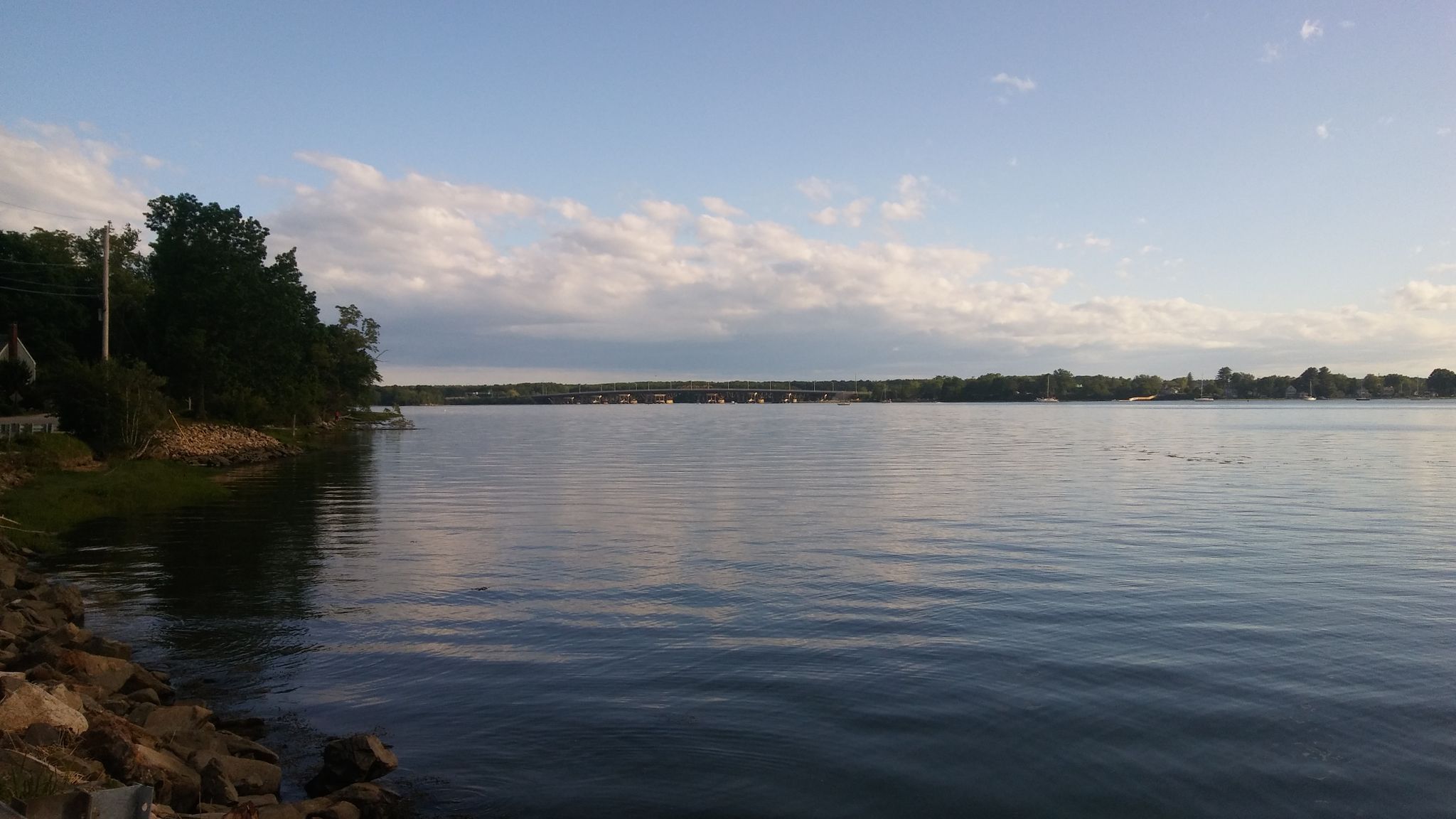 Wide calm water under a partly cloudy sky, with treed shore. - Downtown Portsmouth to River Road loop via Main Street Causeway