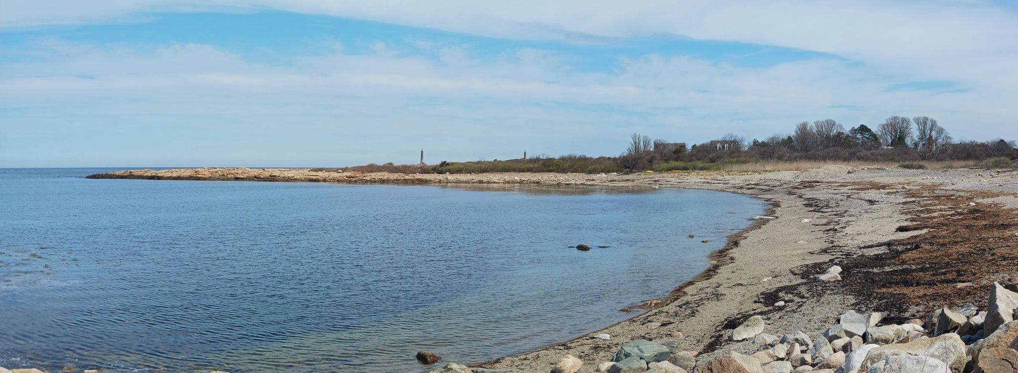 Panoramic view of a calm bay with a sandy beach under a blue sky. - Rockport Harbor – Rockport Harbor loop from Halibut Point State Park