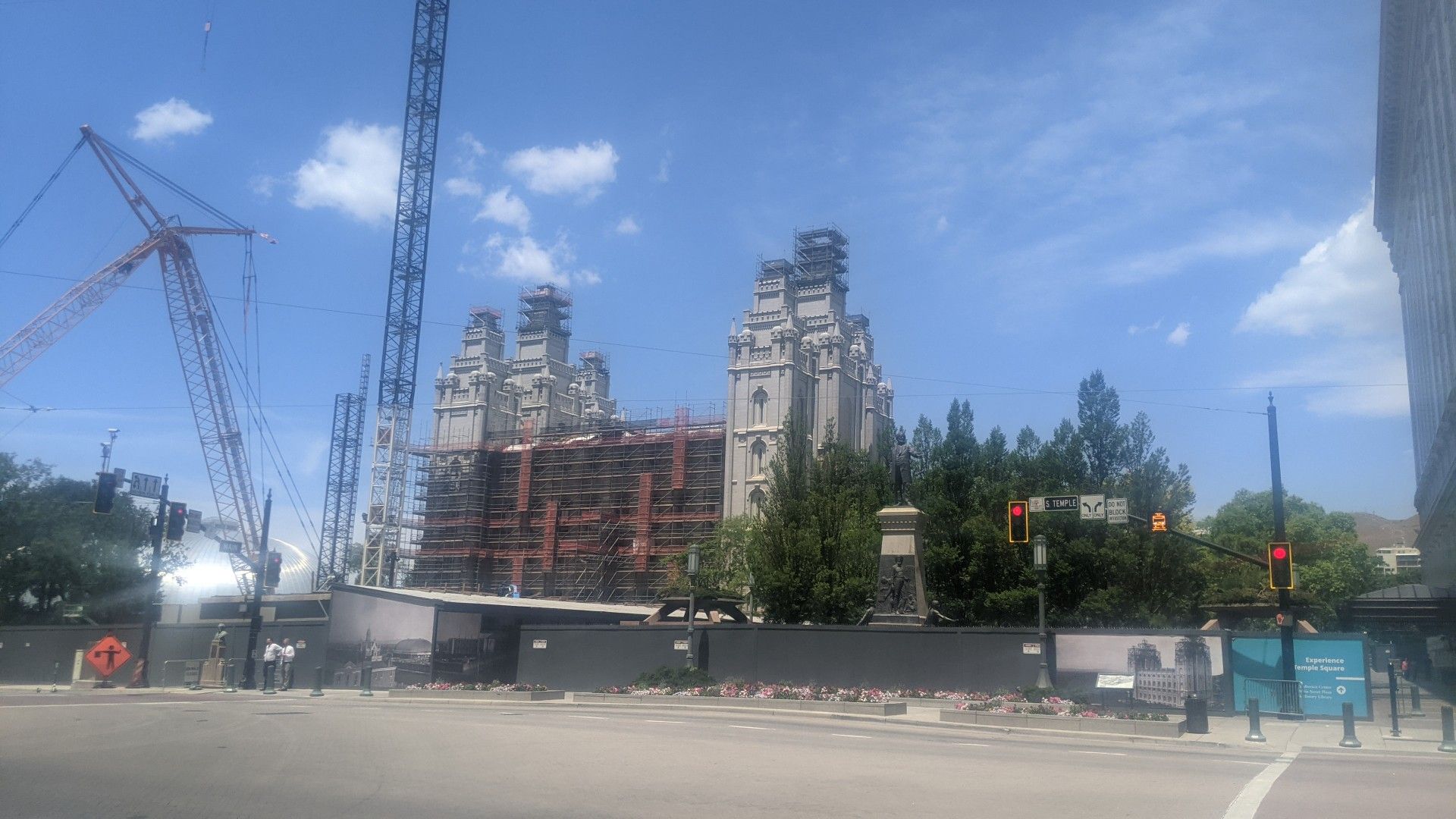 Large building under construction with scaffolding and cranes on a sunny day. - Cycle the City