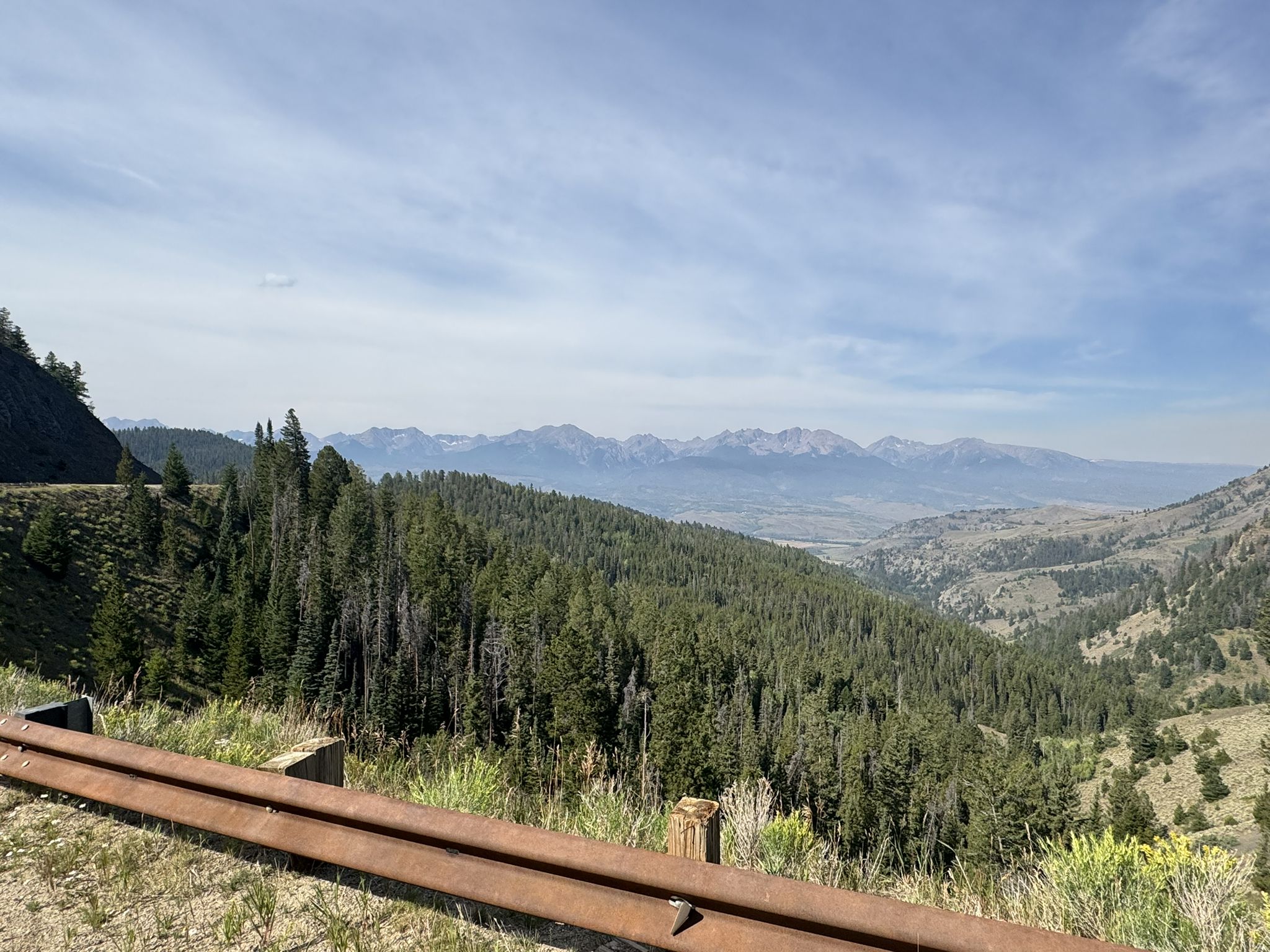 A vast forested valley with distant mountains under a clear sky. - Great Divide Mountain Bike Route