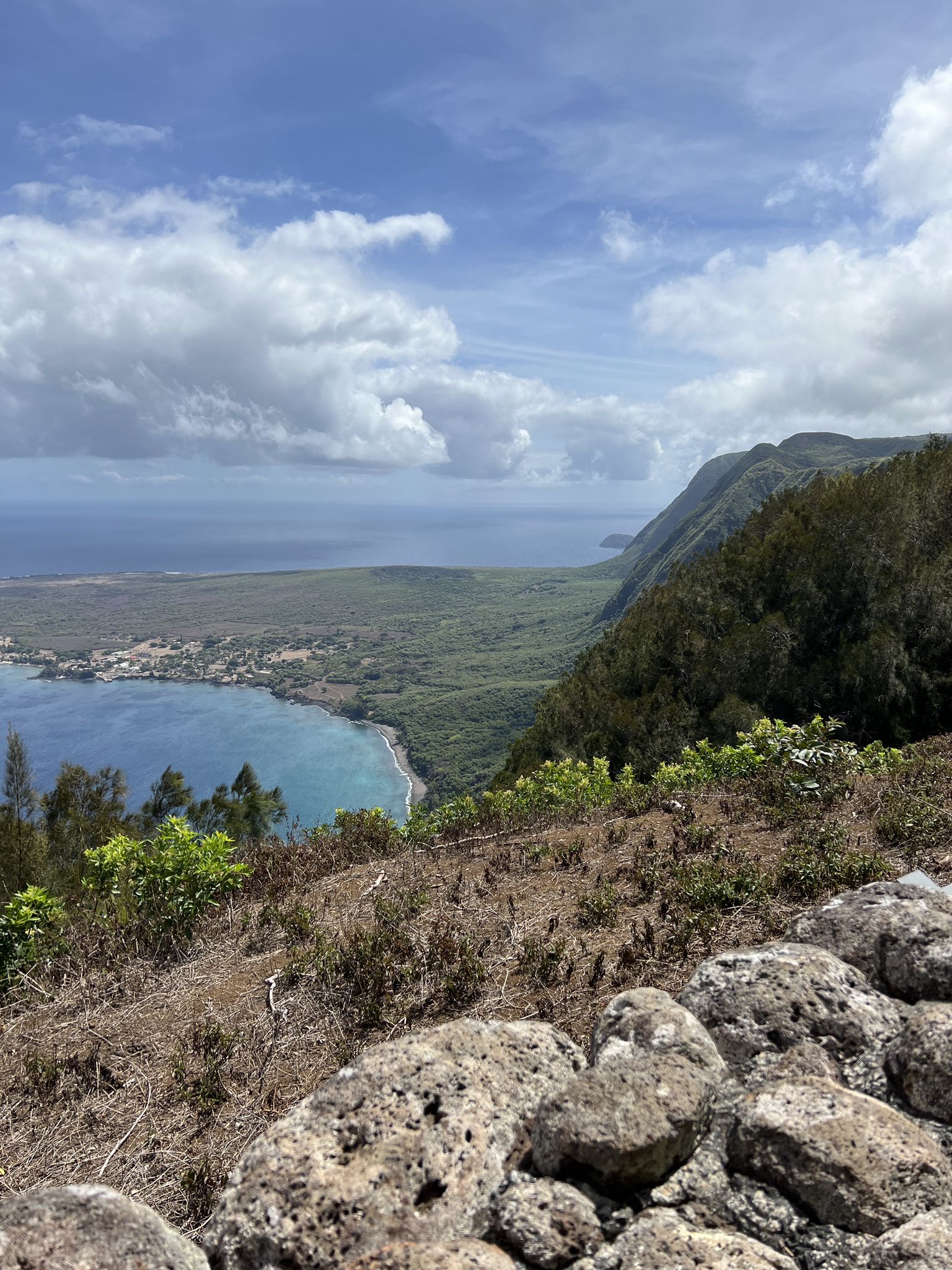 Panoramic view of a blue bay, green valley, and mountains under a cloudy sky. - Phallic Rock & Kalaupapa Lookout run