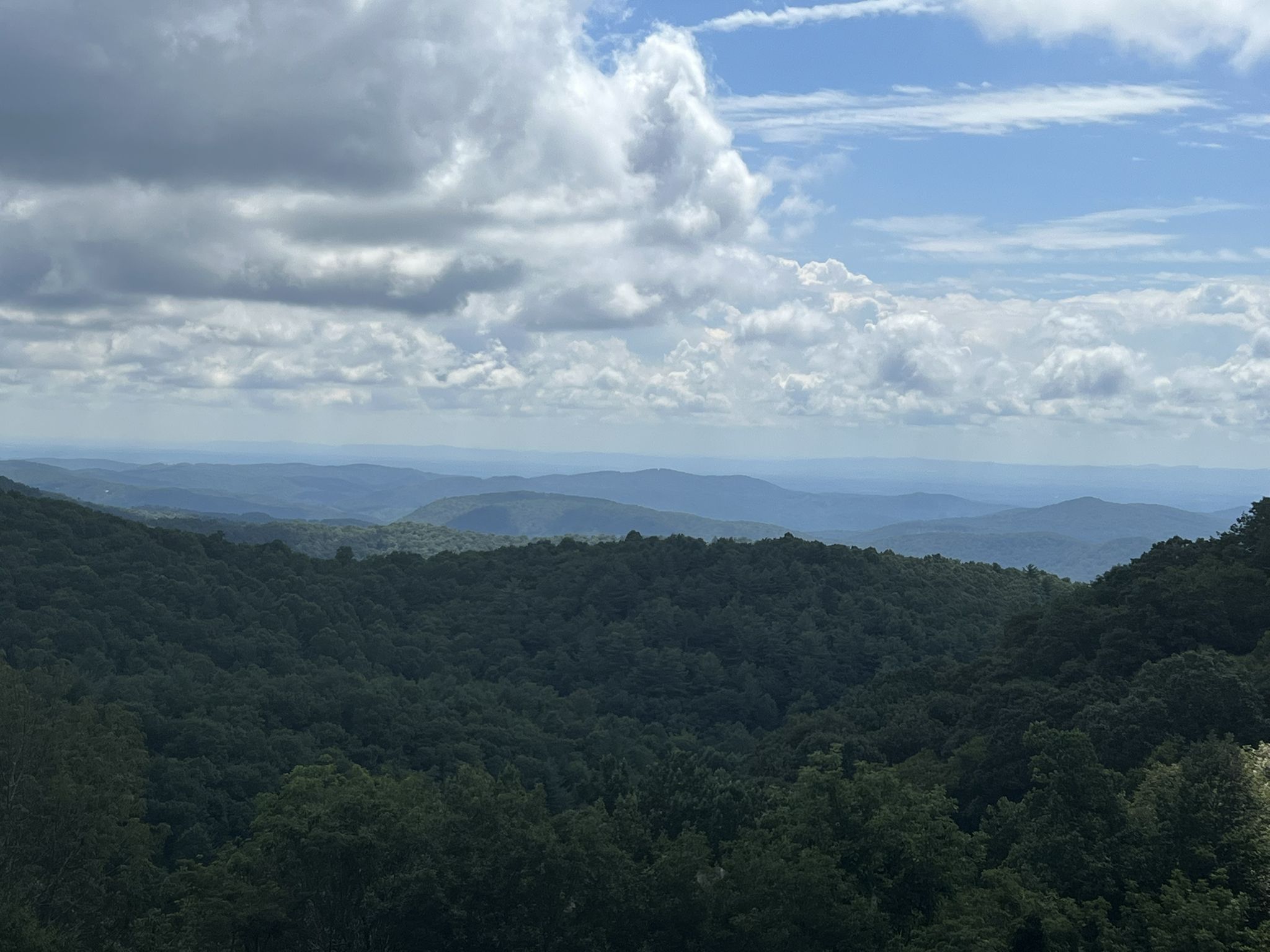 Expansive view of forested mountains under a partly cloudy sky. - Jumpinoff Rock to Basin Cove Overlook