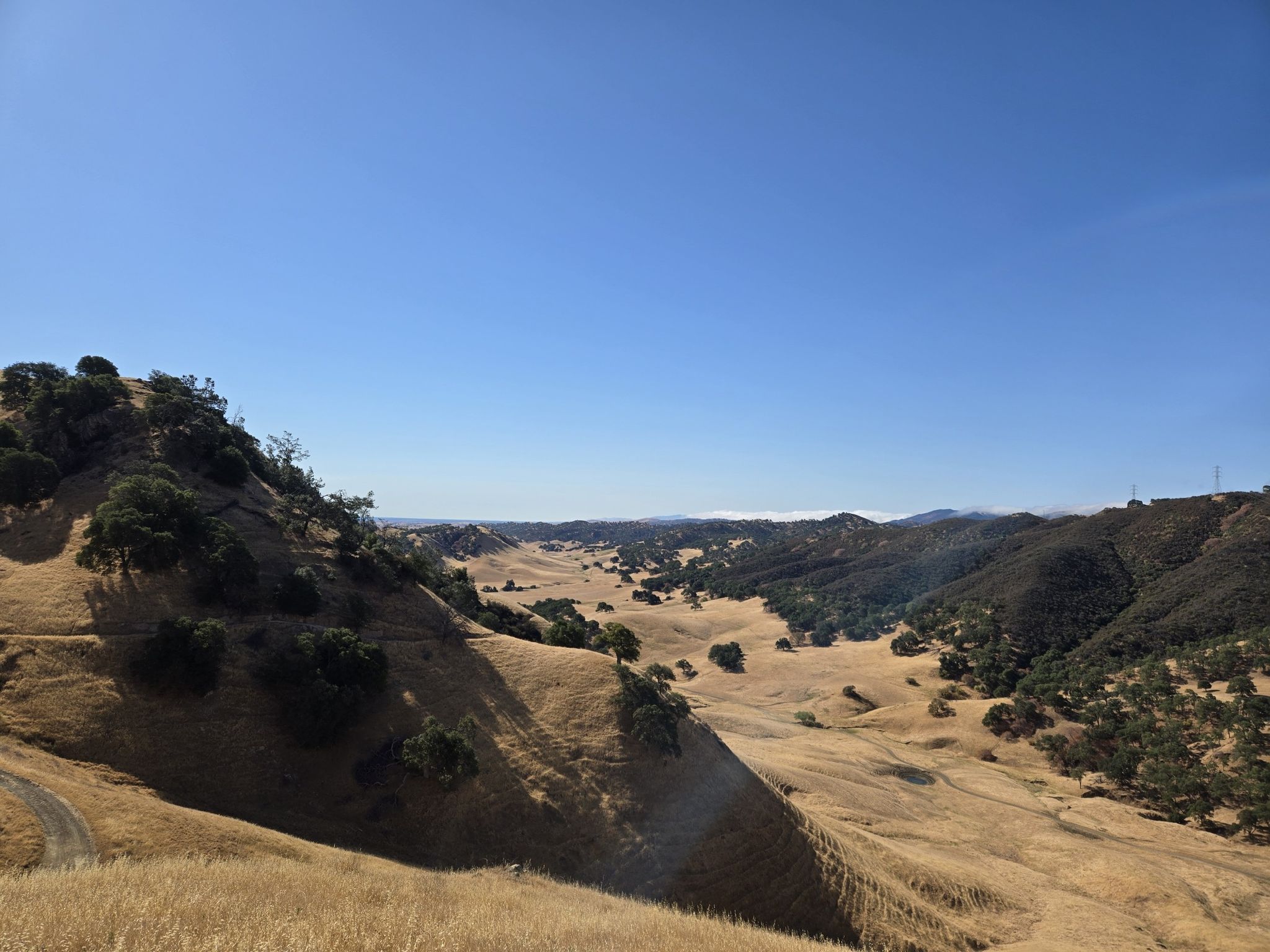 Expansive view of golden hills and a wide valley under a bright blue sky. - Stewartville Trail loop from Deer Valley High School