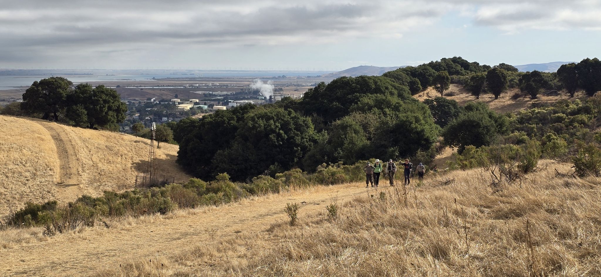 A group of people hike on a dirt path through dry hills. - Franklin Ridge Loop