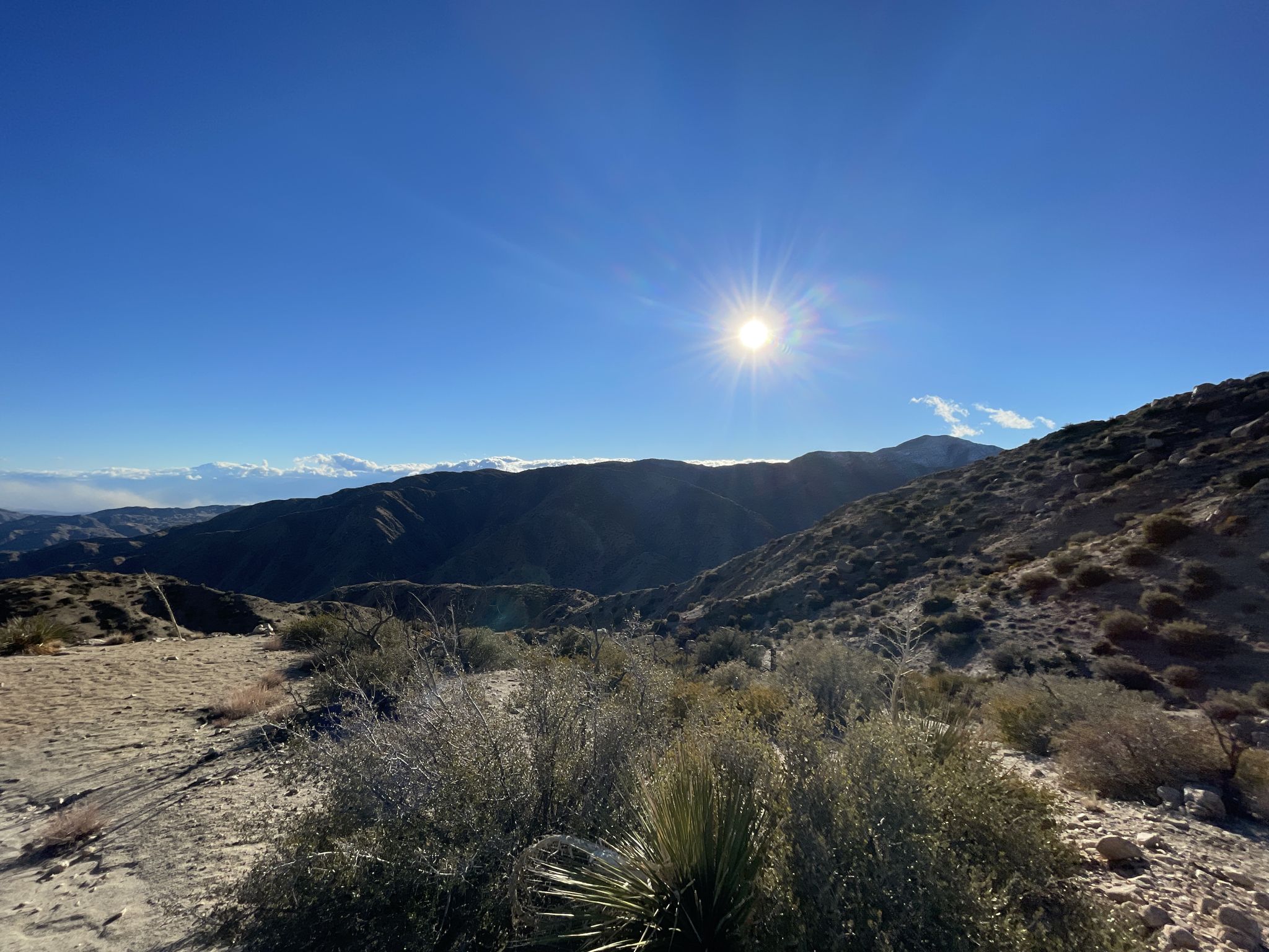 Bright sun over arid mountains with sparse vegetation under a clear blue sky. - Running loop from Sawtooth Mountains Trailhead