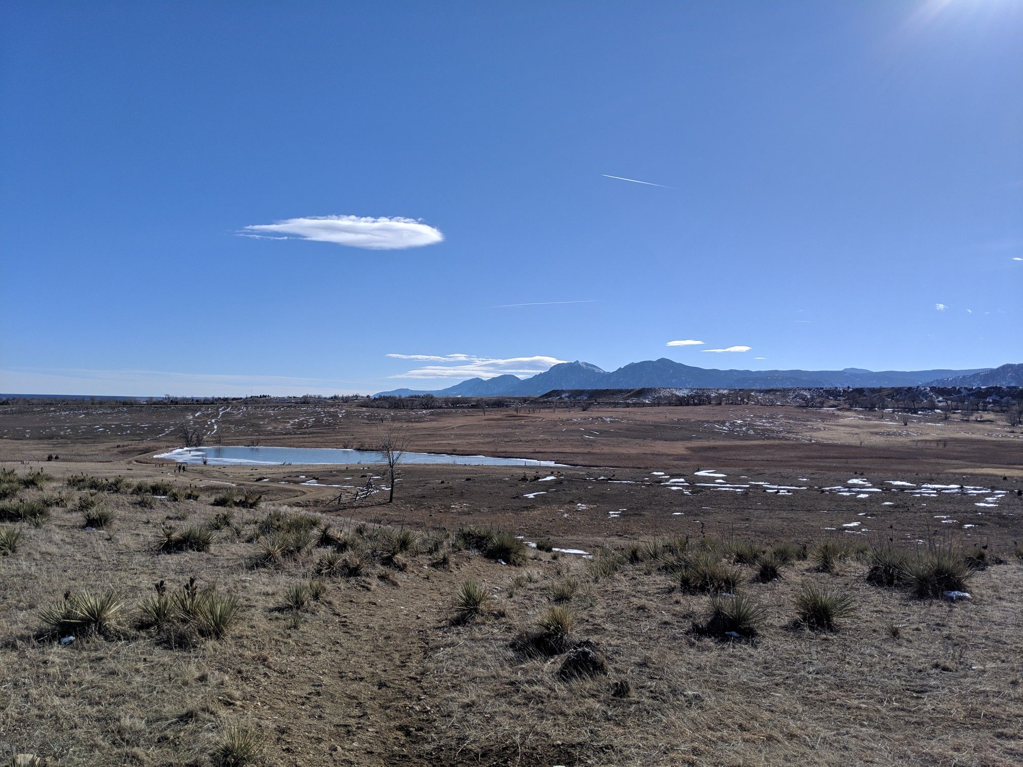 Wide landscape with a small lake, dry grass, and distant mountains. - Boulder Valley Ranch Pond – Boulder Valley Ranch loop from Boulder Open Space and Mountain Parks