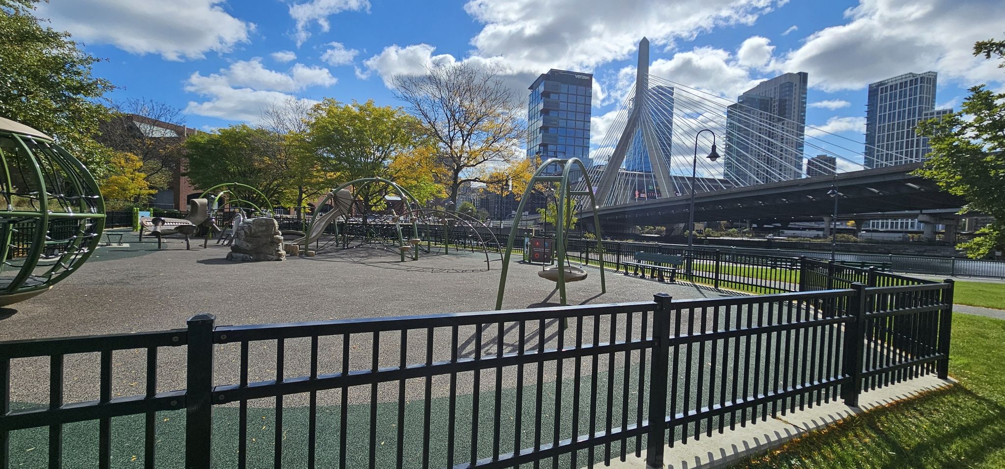 A playground with swings and climbing structures, city skyline in background. - Paul Revere Park – Bunker Hill Monument loop from Wyoming Hill