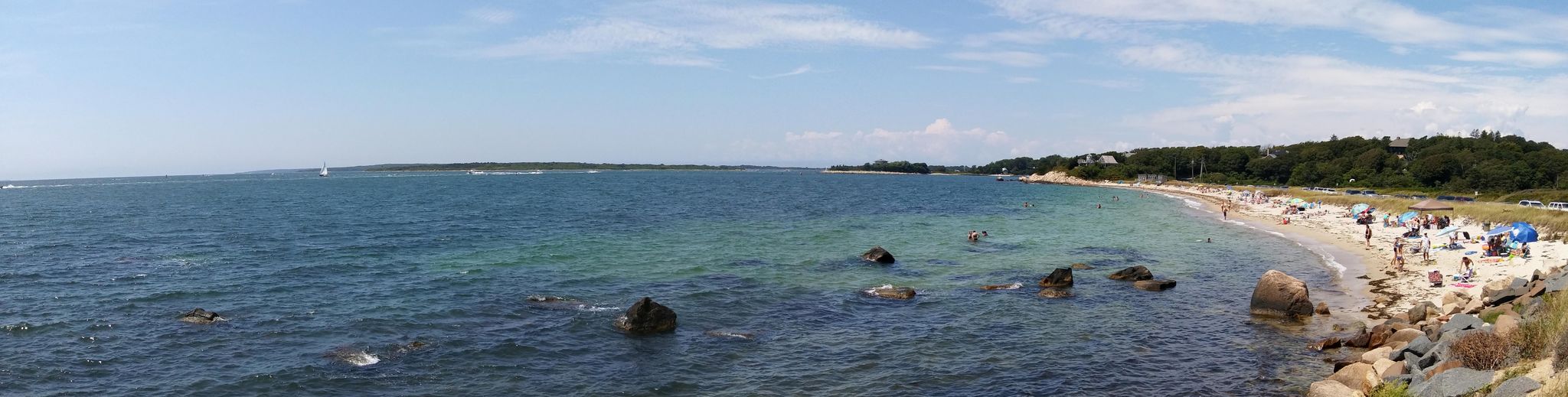 Panoramic view of a busy sandy beach with people enjoying the blue ocean. - Nobska Beach – Nobska Lighthouse loop from Woods Hole