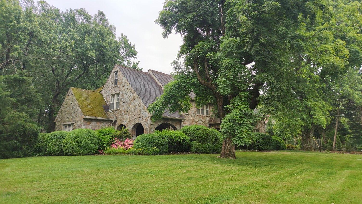 A large stone house with a green roof, surrounded by lush trees and lawn. - Tennessee Riverwalk and Lookout Mountain Loop