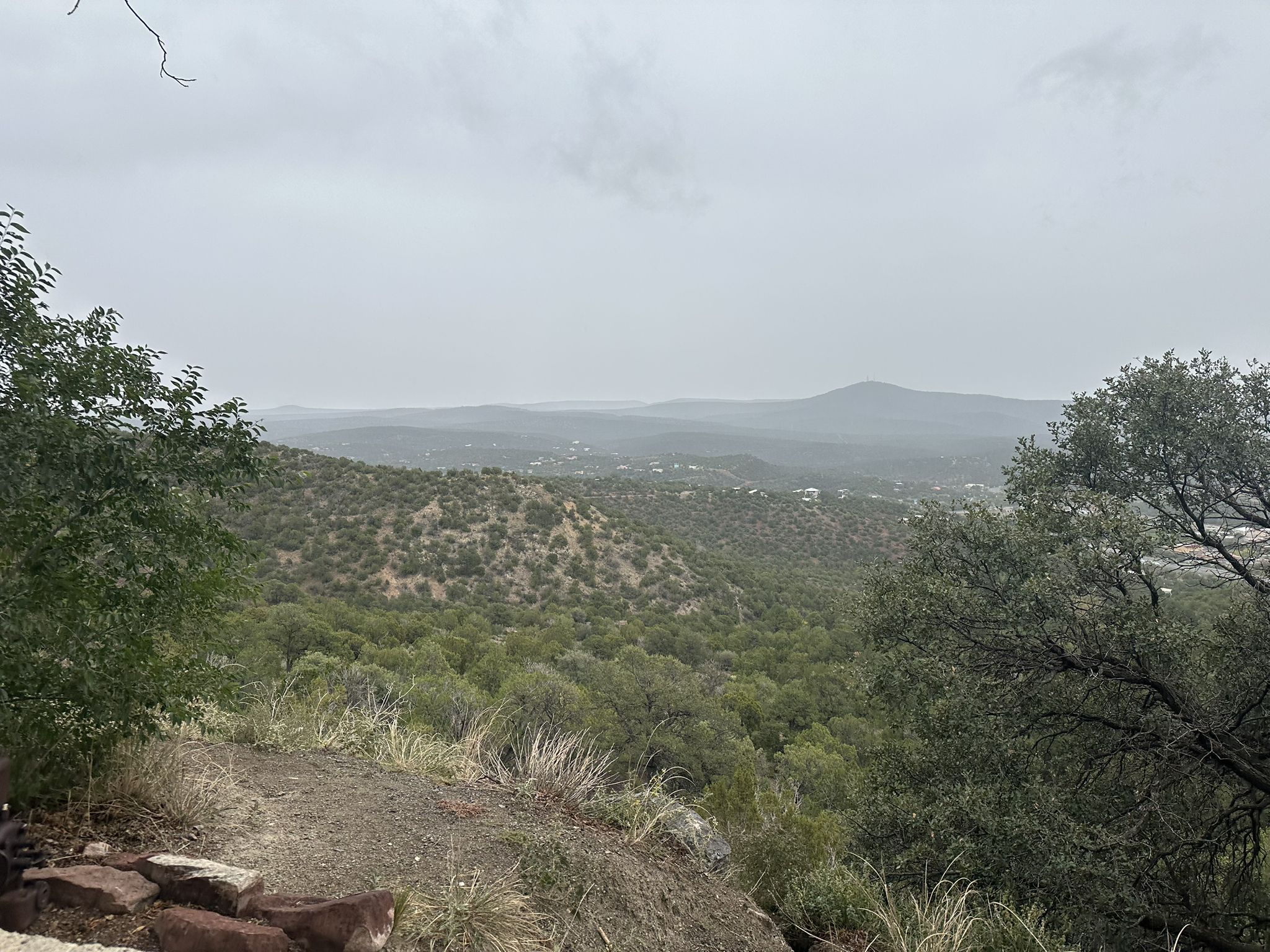 Overcast view of green, rolling hills and distant mountains. - South Crest Trail