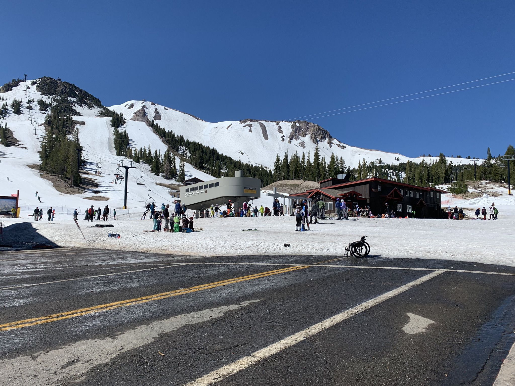 Sunny day at a busy ski resort with many people on snow-covered slopes. - Village Plaza – Mammoth Mountain Resort loop from Eagle Lodge