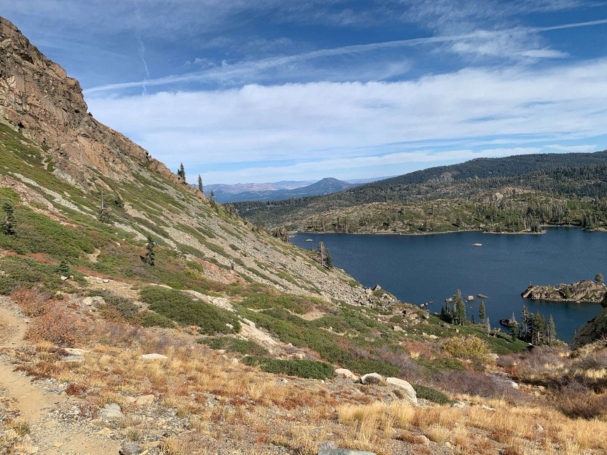 A scenic view of a large lake nestled among rocky, forested mountains. - Long Lake Loop Trail