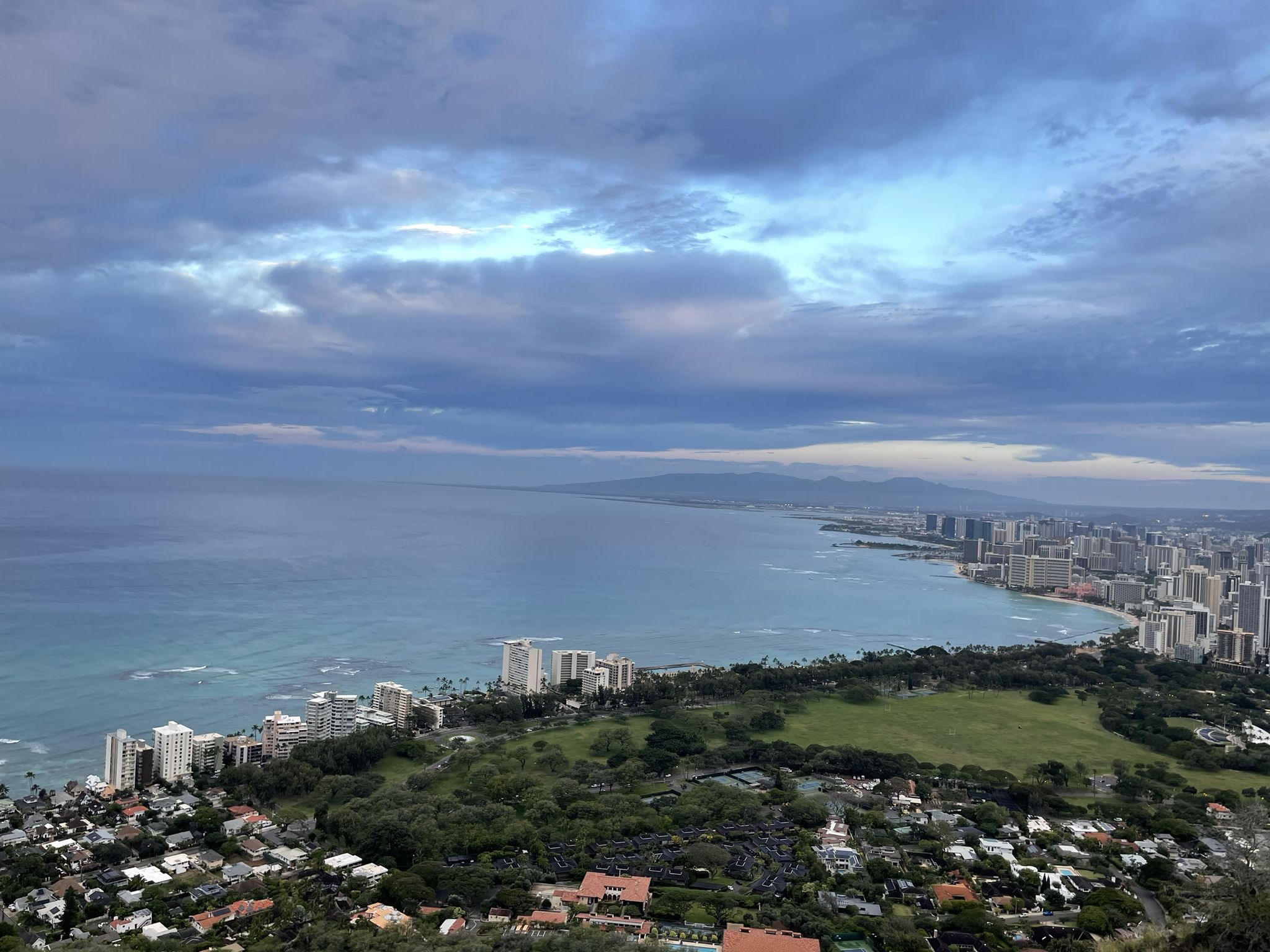 Panoramic view of a coastal city and ocean under a cloudy sky. - Kapiʻolani Community College loop via Fort Ruger Pathway