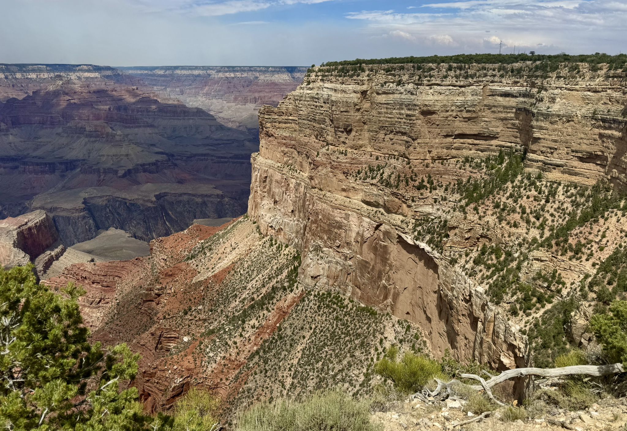 Massive, layered rock cliff face overlooking a vast canyon under a partly cloudy sky. - Hopi Point viewpoint – Mohave Point loop from Kolb Studio