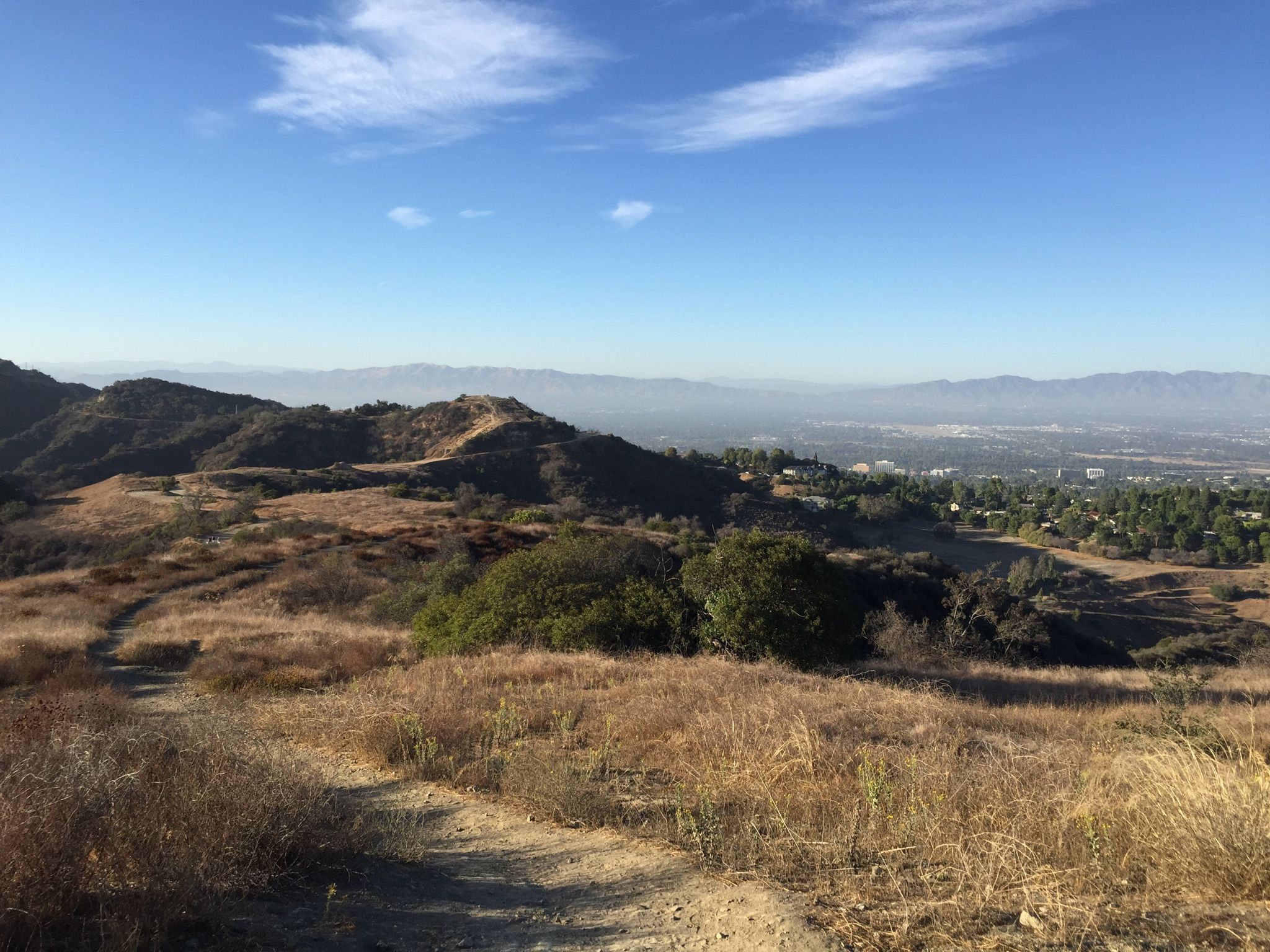 Sunny view of dry, rolling hills with a dirt path and distant valley. - Hiking loop from Santa Monica Mountains