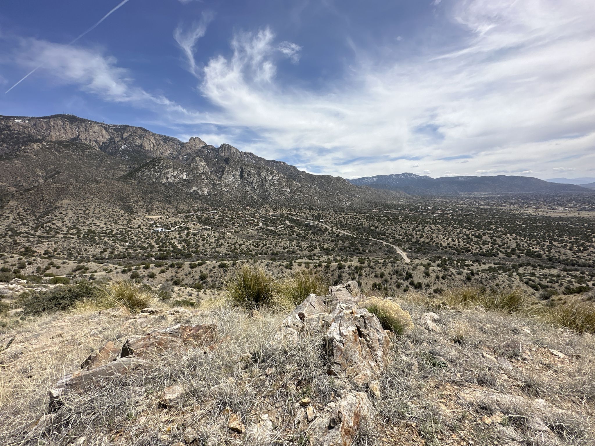 Wide view of a rugged mountain range and dry valley under a cloudy sky. - Juan Tabo Canyon Loop