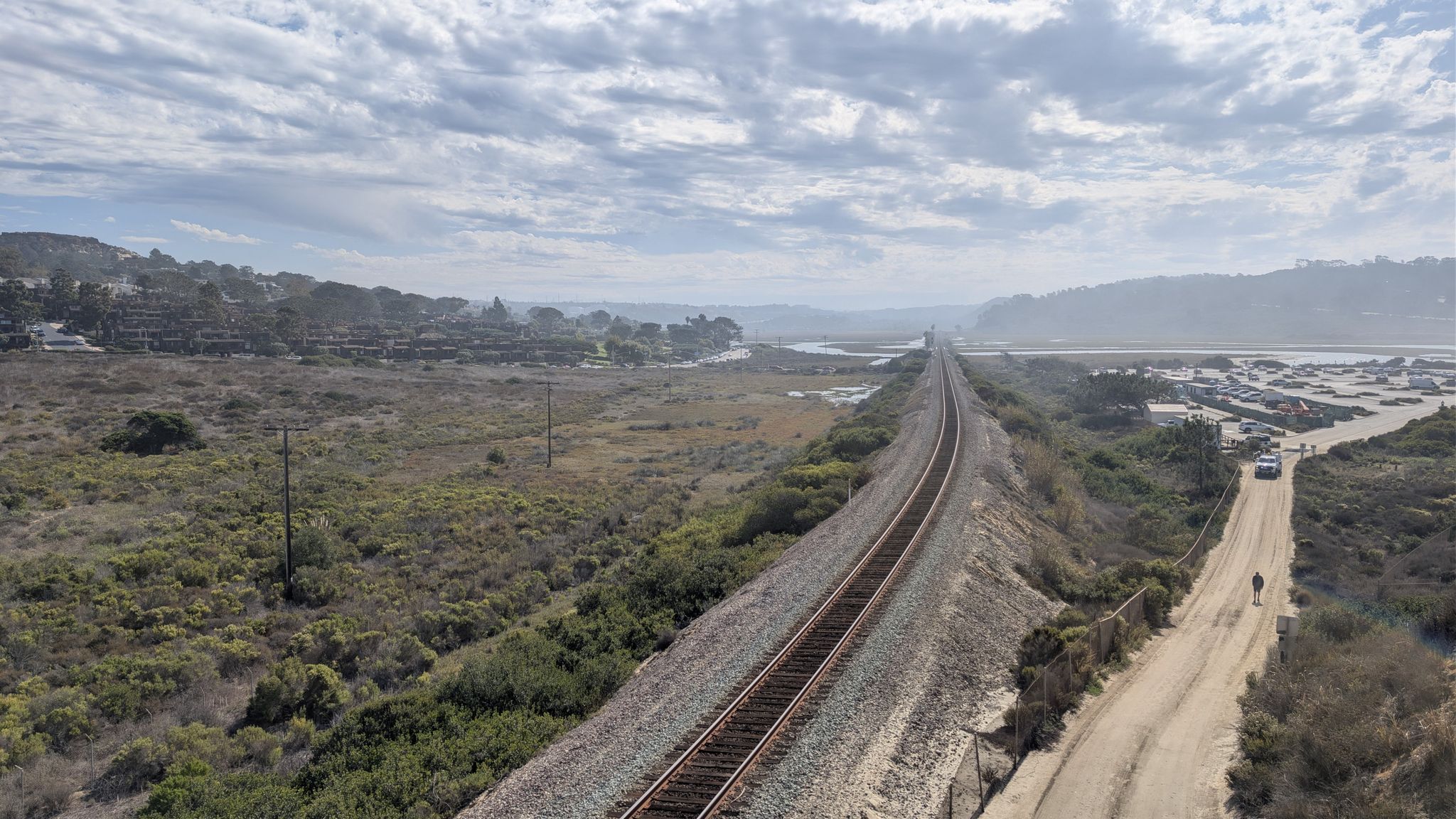 Cloudy day over long train tracks, dirt road, and marshland. - Encinitas/Del Mar loop