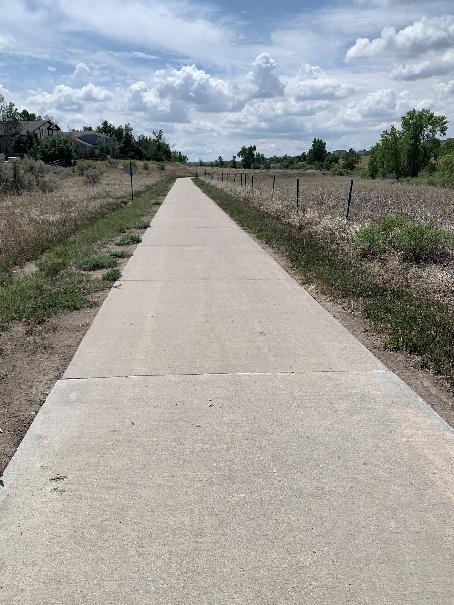 Long, straight paved path through dry fields under a cloudy sky. - Rueter-Hess Reservoir – The Cherry Creek Trail loop from RidgeGate Parkway