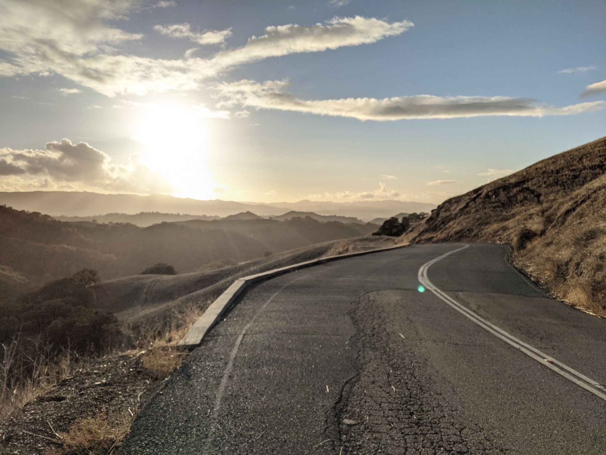 Winding road on a hillside at sunset with golden light. - Mount Diablo and Iron Horse Trail Loop
