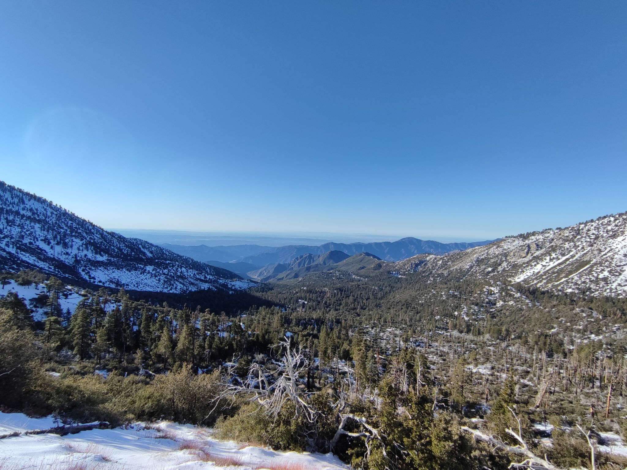 Sunny view of a snow-covered mountain valley with distant peaks. - Windy Gap & Mount Islip – Angeles National Forest