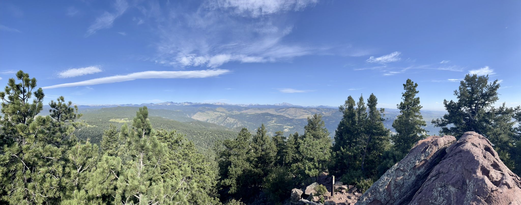 Panoramic mountain view with pine trees and distant peaks under a blue sky. - Green Mountain West Ridge Trail