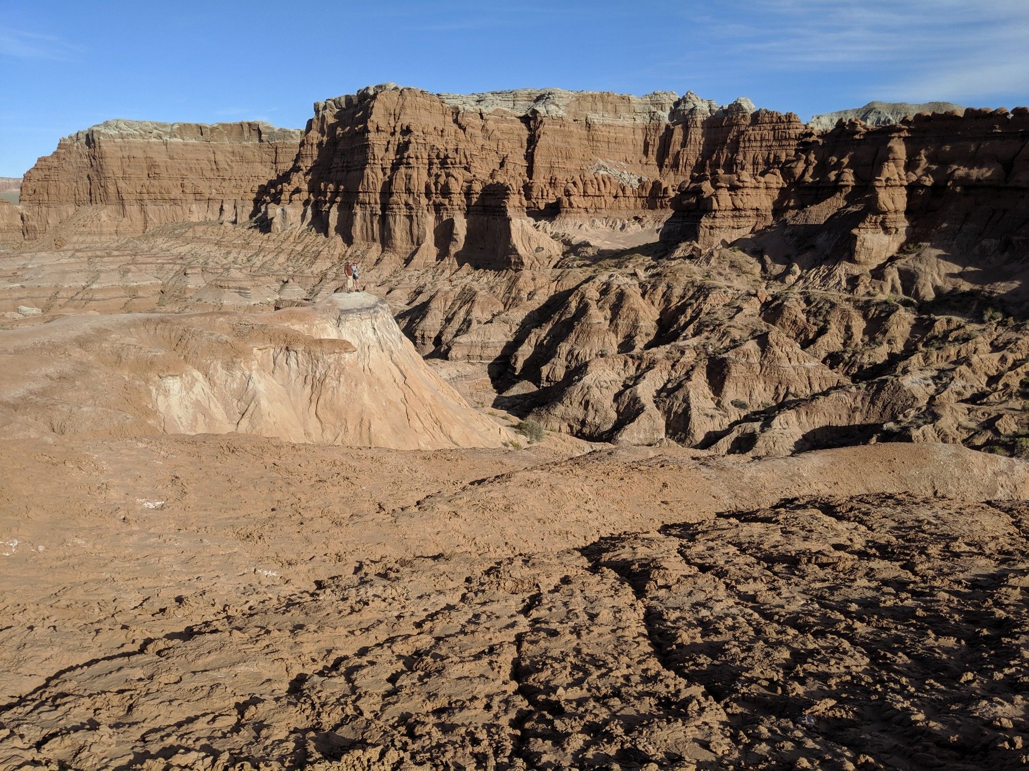 Panoramic view of a vast desert canyon with layered cliffs and eroded terrain. - Carmel Canyon Loop Trail