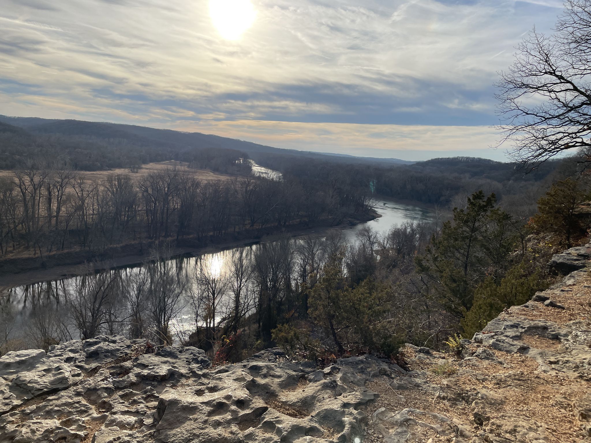 Panoramic view of a winding river through a forested valley under a bright, cloudy sky. - Riverscene Trail running loop