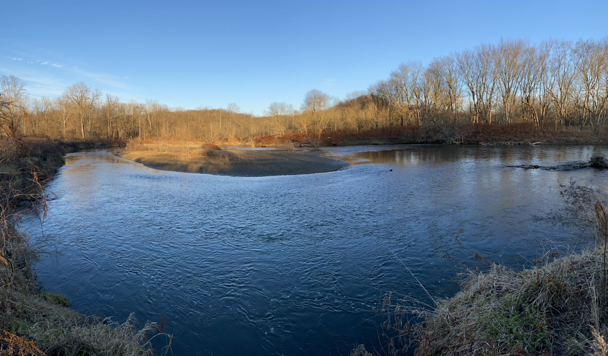 A wide river flows through a bare winter landscape under a clear blue sky. - Buckeye and Towpath Trail Loop