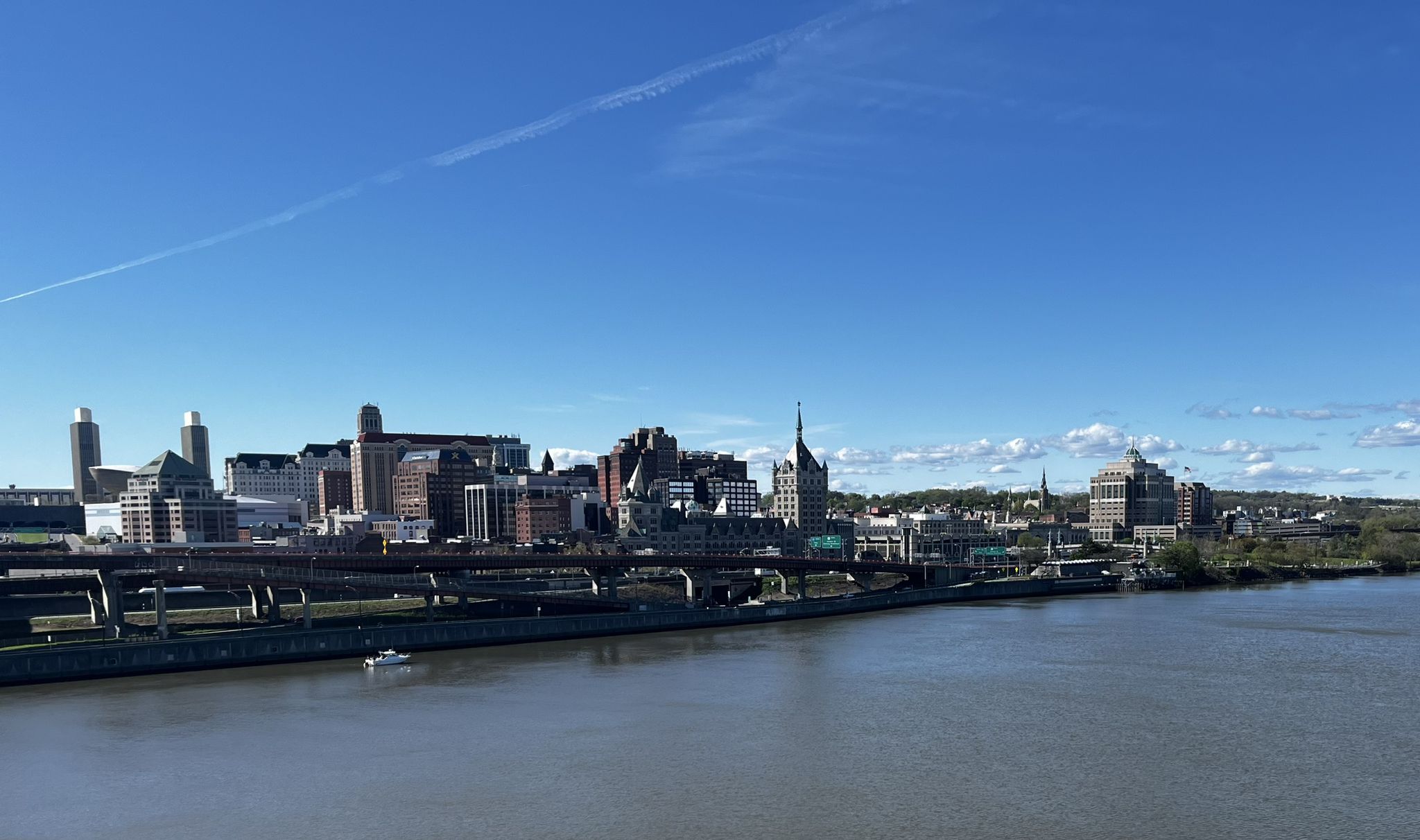 City skyline along a wide river under a clear blue sky. - Mohawk-Hudson Bike-Hike Trail - Uncle Sam Trail Loop