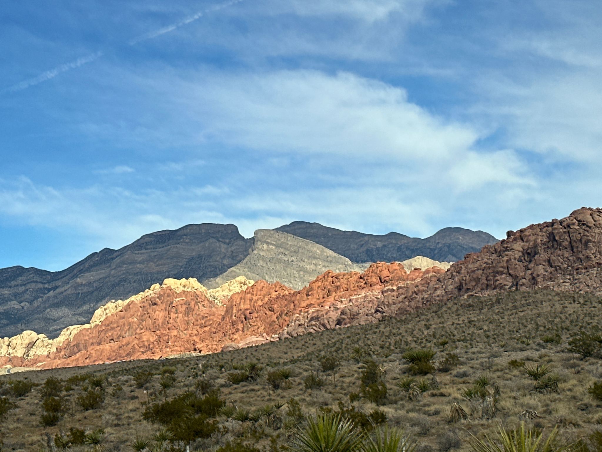 Desert mountains with red and gray rock formations under a blue sky. - Cowboy Trails Parking Lot – Red Rock Canyon Overlook loop from Summerlin South