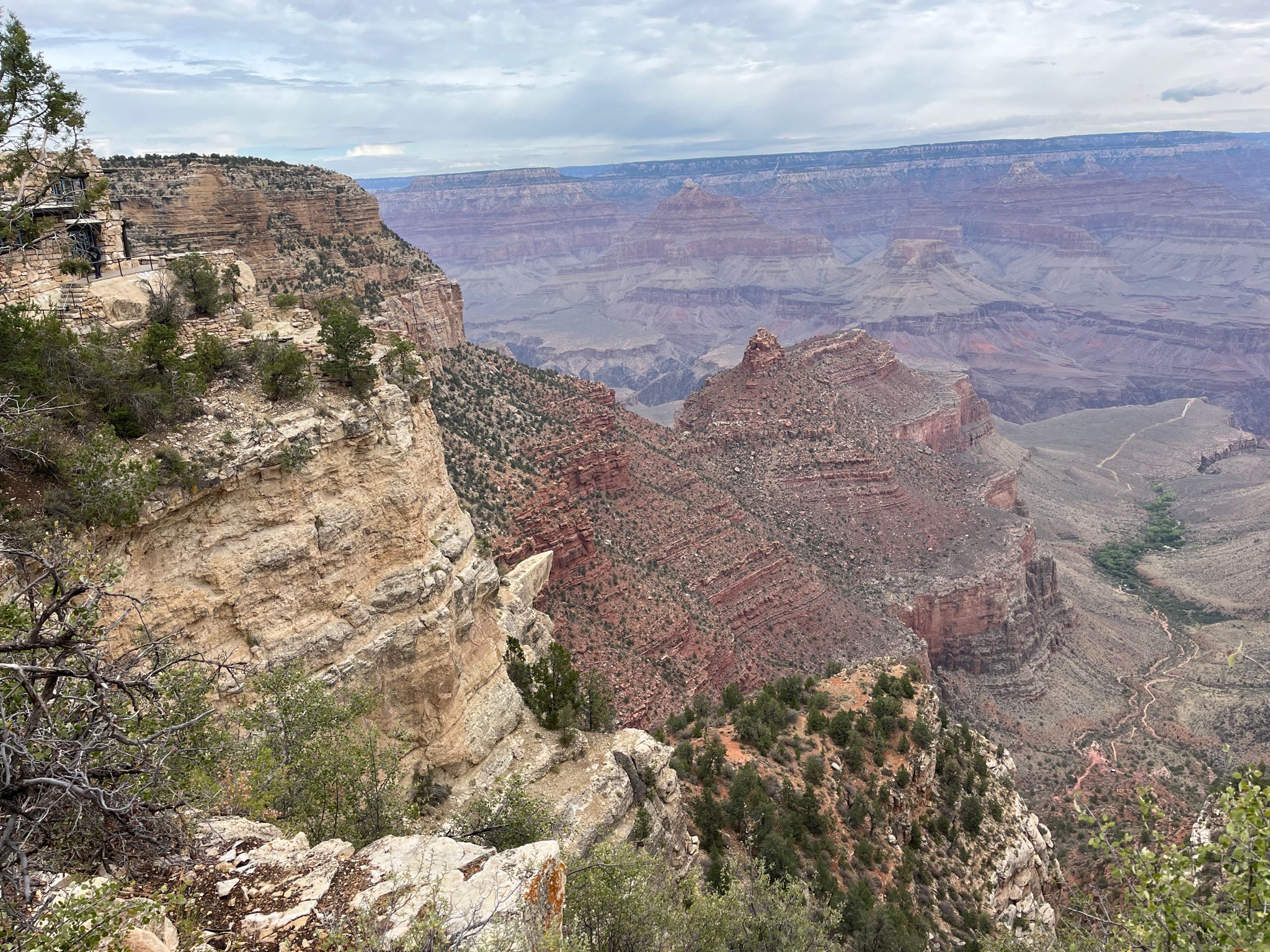 Expansive view of a deep, rugged canyon with layered rock and sparse vegetation. - View of the Grand Canyon – Hopi House loop from Grand Canyon Village