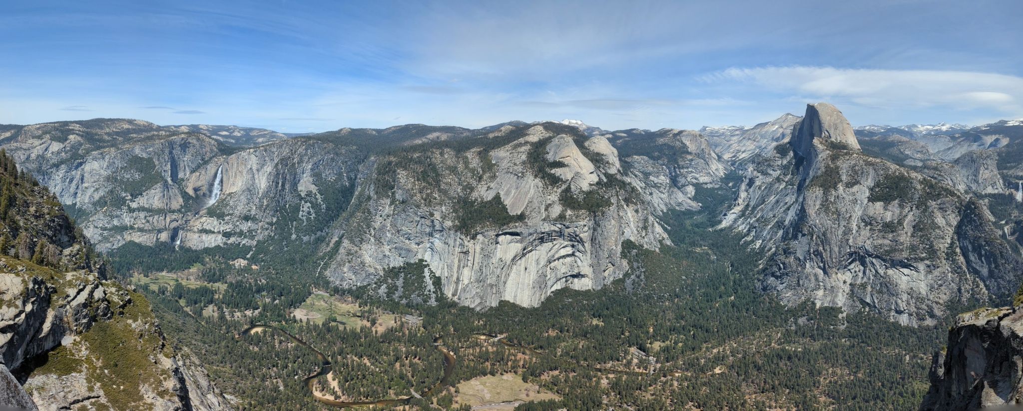 Expansive panoramic view of a mountain range with a prominent granite dome. - Glacier Point Trail