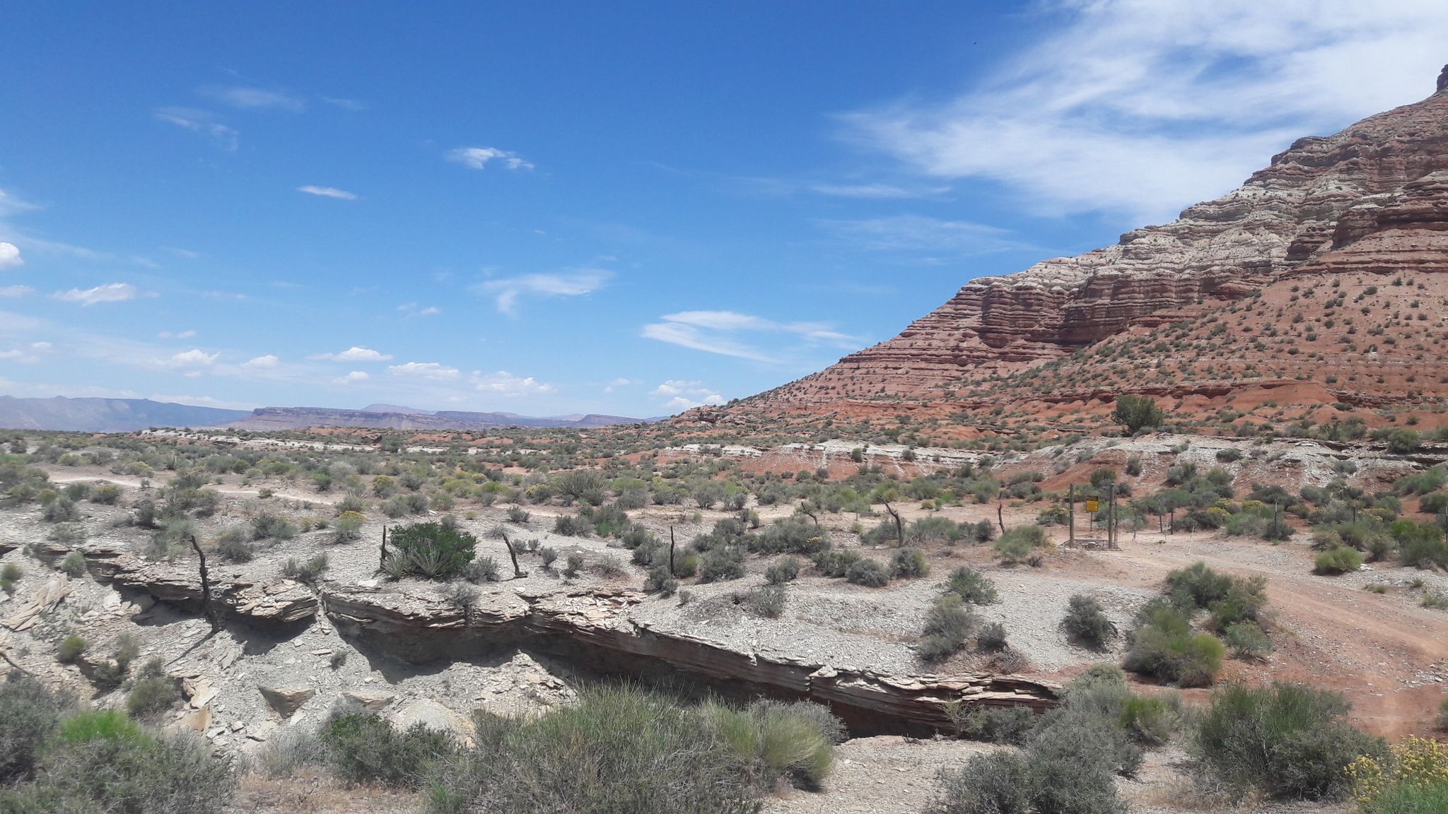 Sunny desert landscape with red rock formations and sparse green brush under blue sky. - JEM, Dead Ringer, and Goosebumps Loop