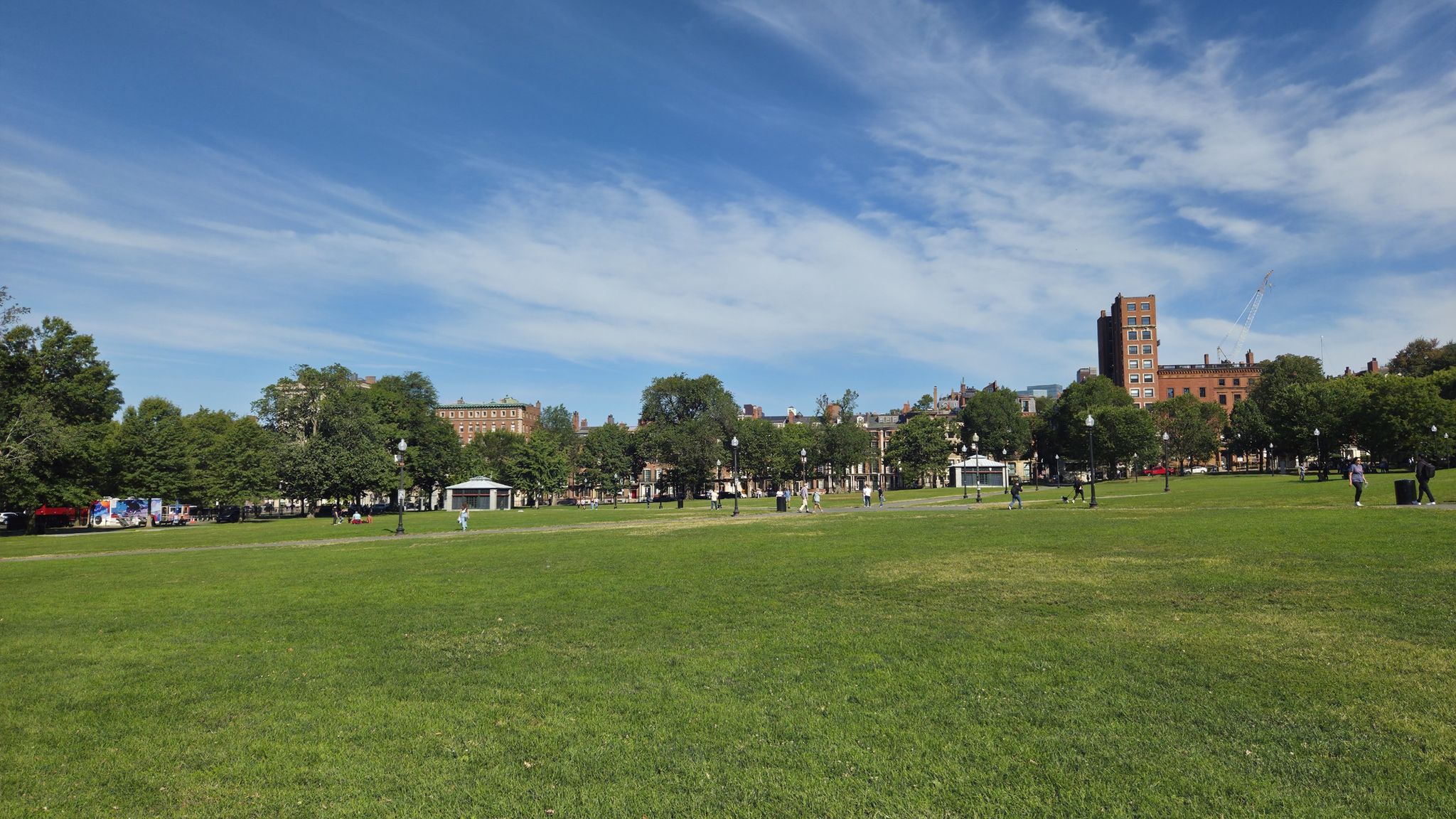 Wide green lawn with distant buildings and trees under a blue sky. - Boston loop from Crystal Lake to Paul Revere Park via Commonwealth Avenue Mall & Boston Common