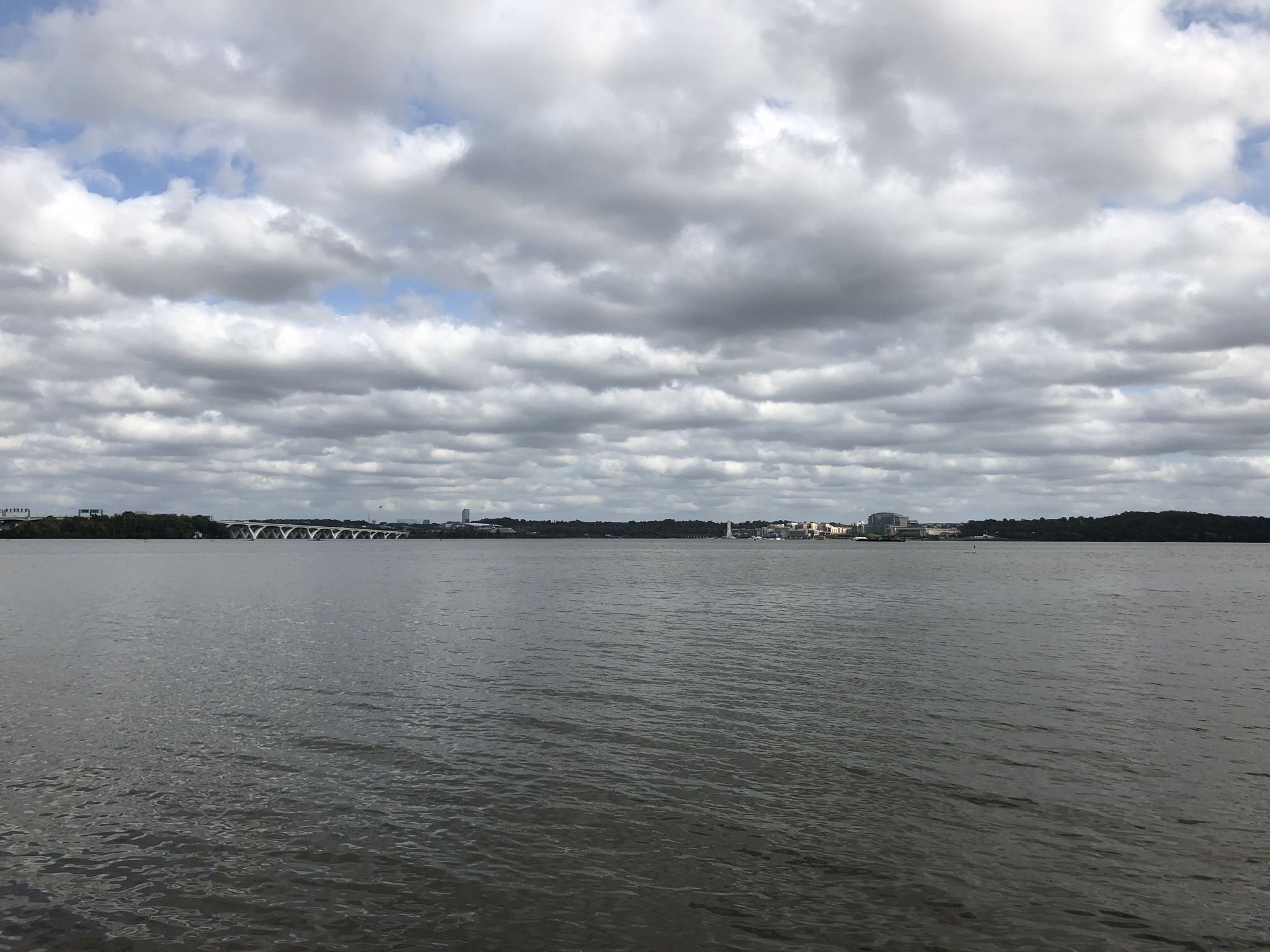 Wide expanse of water under a cloudy sky with distant structures. - Belle Haven Park – Mount Vernon Trail loop from Belle Haven