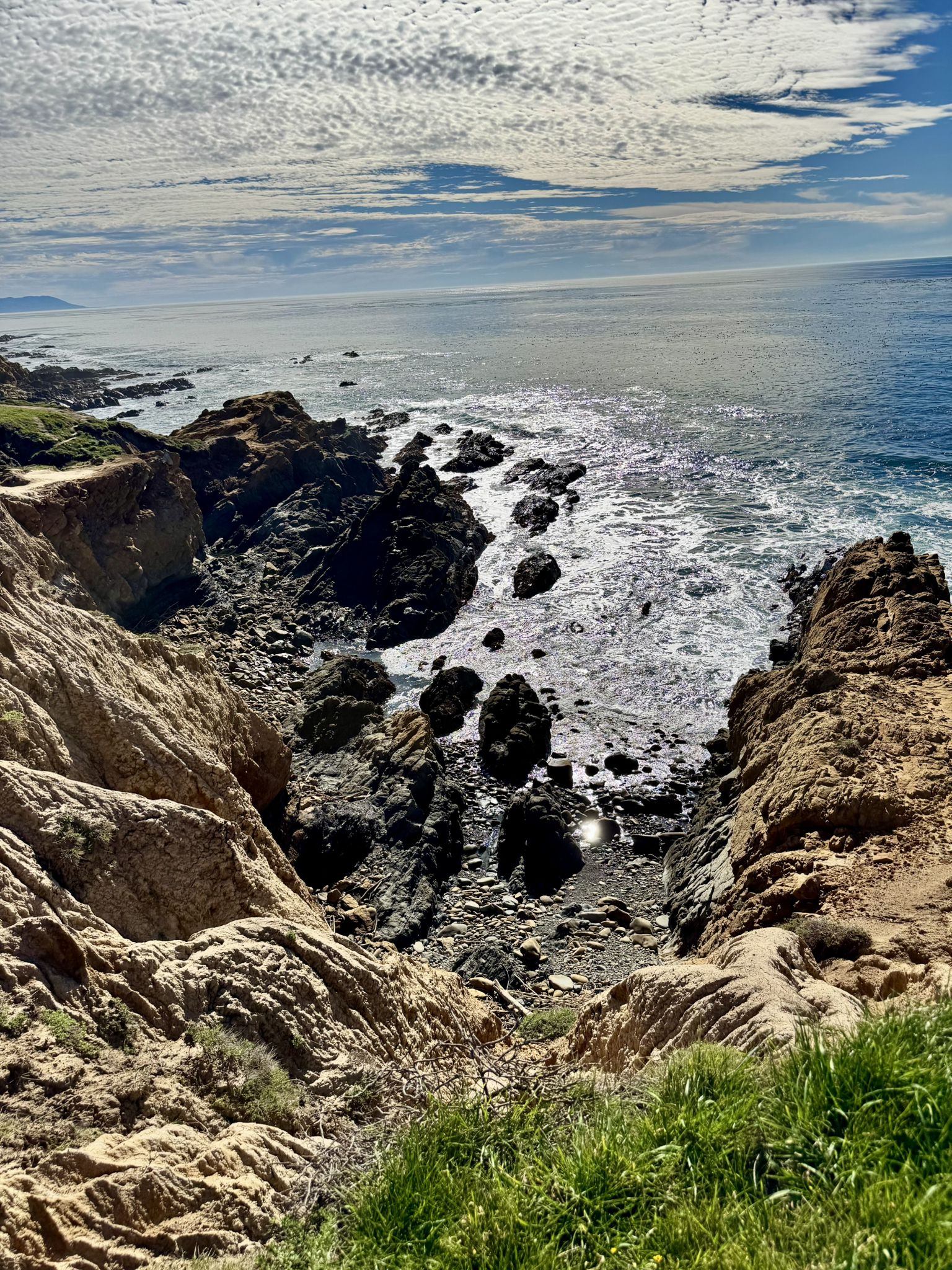 Rocky coastline with ocean waves crashing below, under a partly cloudy sky. - Harmony Headlands State Park loop from Harmony Headlands State Park