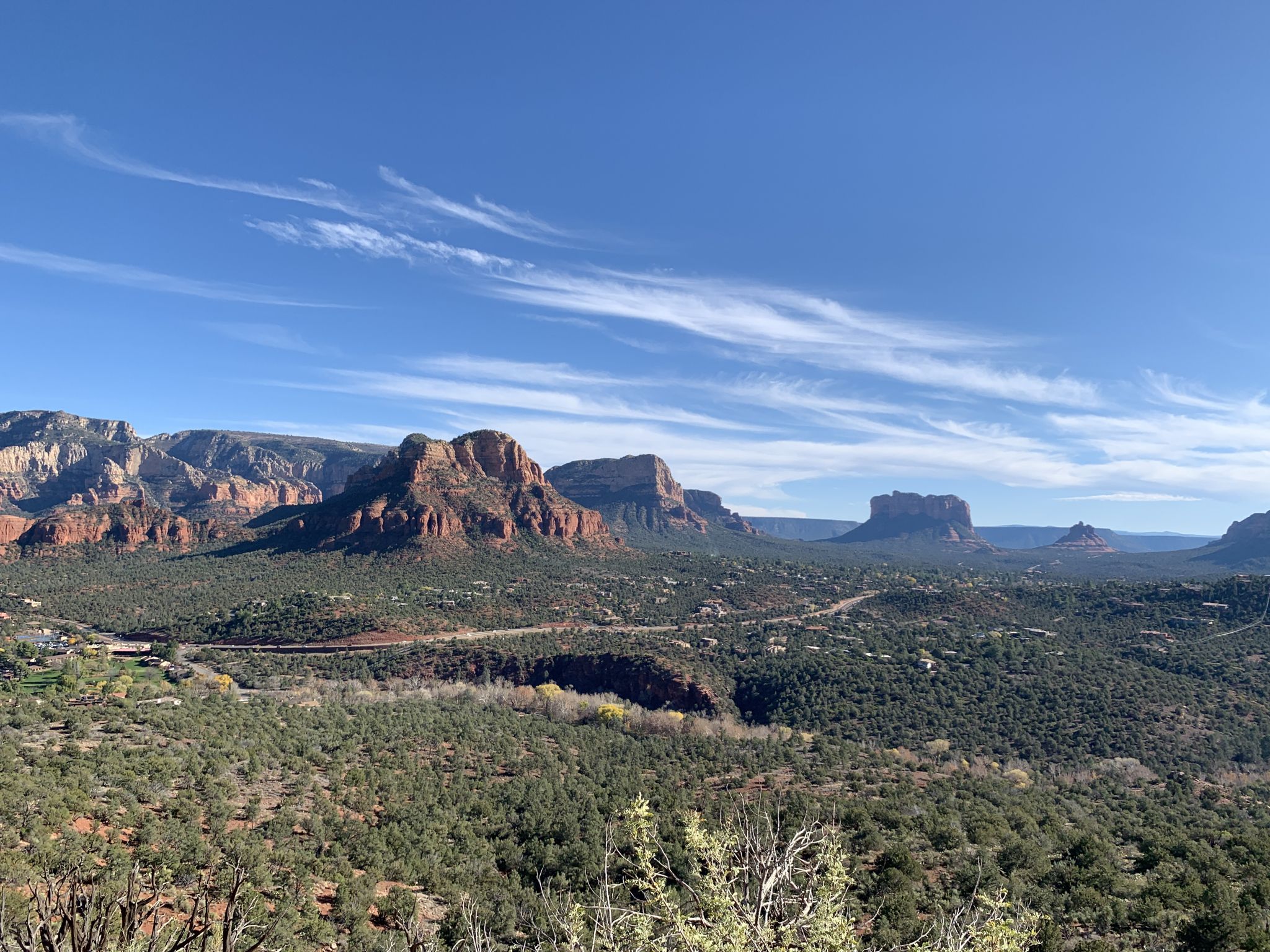 Sunny panoramic view of red rock mountains and green valley under blue sky. - Airport Loop Trail