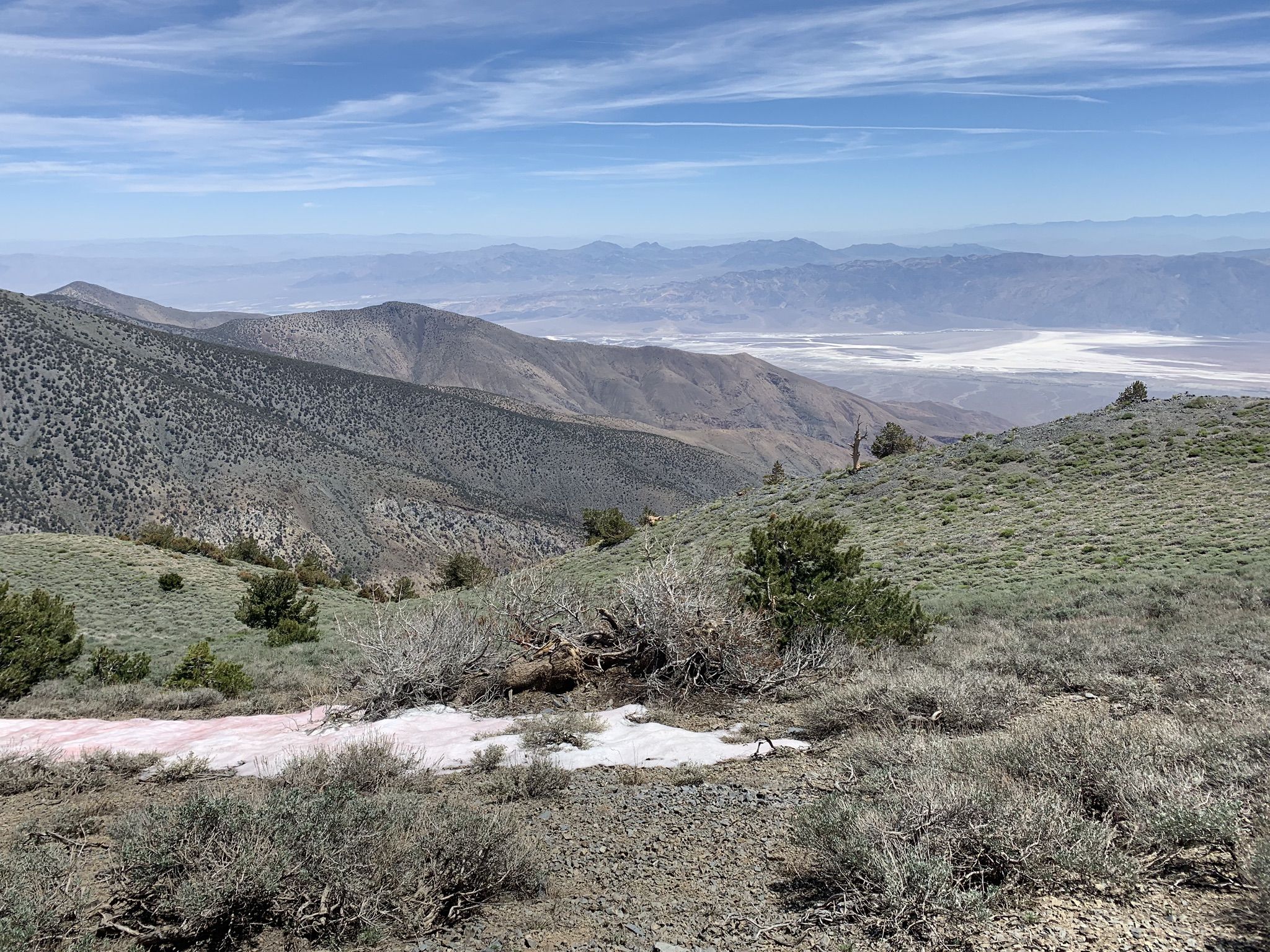 Mountain landscape with patches of snow, distant valley, and blue sky. - Telescope Peak Trail