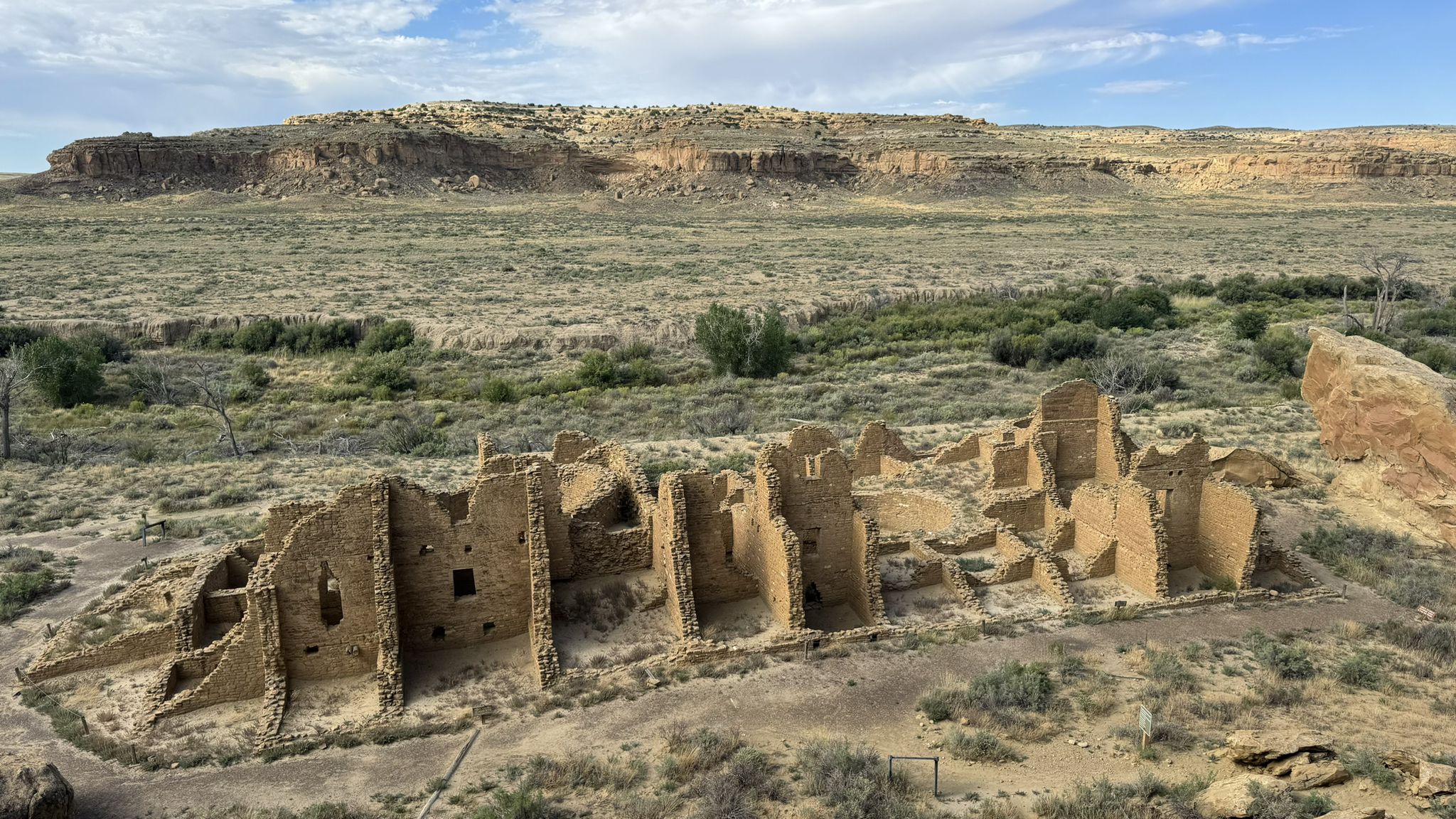 Aerial view of ancient stone ruins in a desert landscape under cloudy sky. - Pueblo Alto – Kin Kletso loop from Pueblo Bonito Great House
