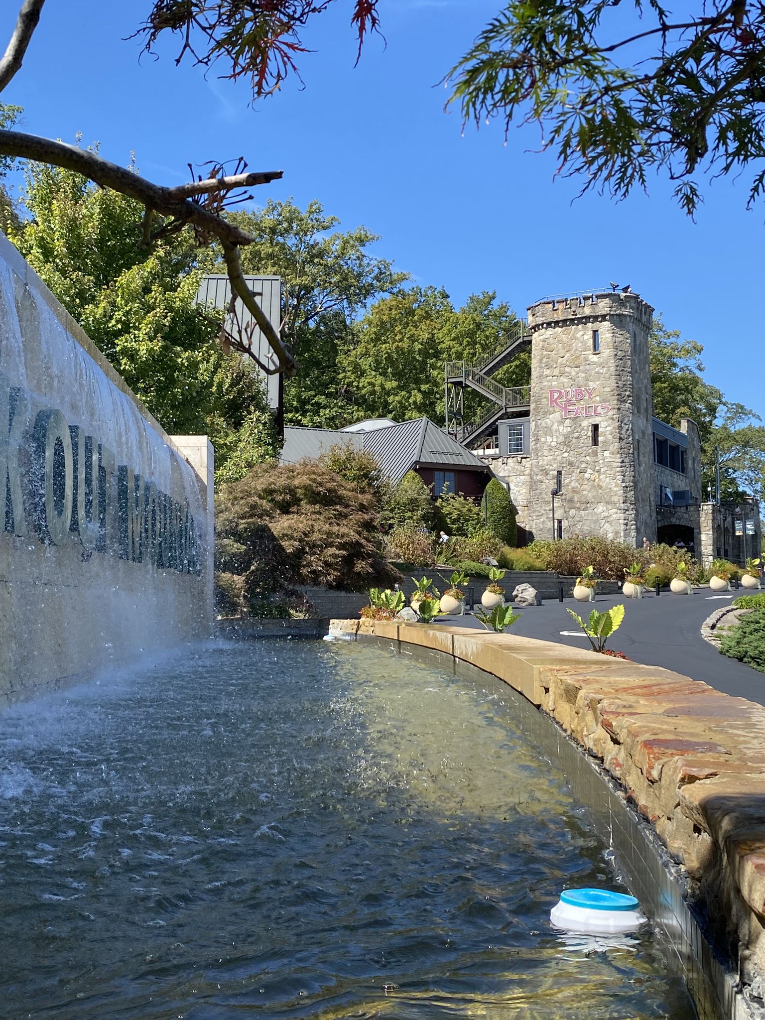 Stone castle-like building next to a large fountain on a sunny day. - Chattanooga loop via Cameron Hill