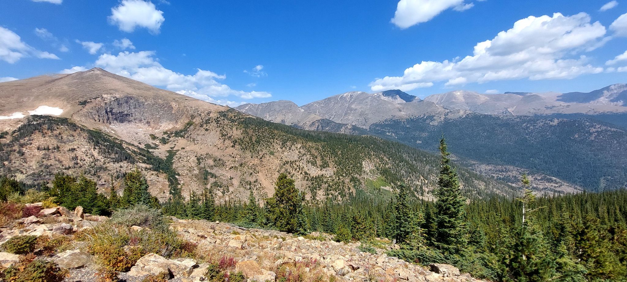 Expansive mountain landscape with forests and rocky slopes under a bright sky. - Many Parks Curve Viewpoint loop from Hidden Valley Parking